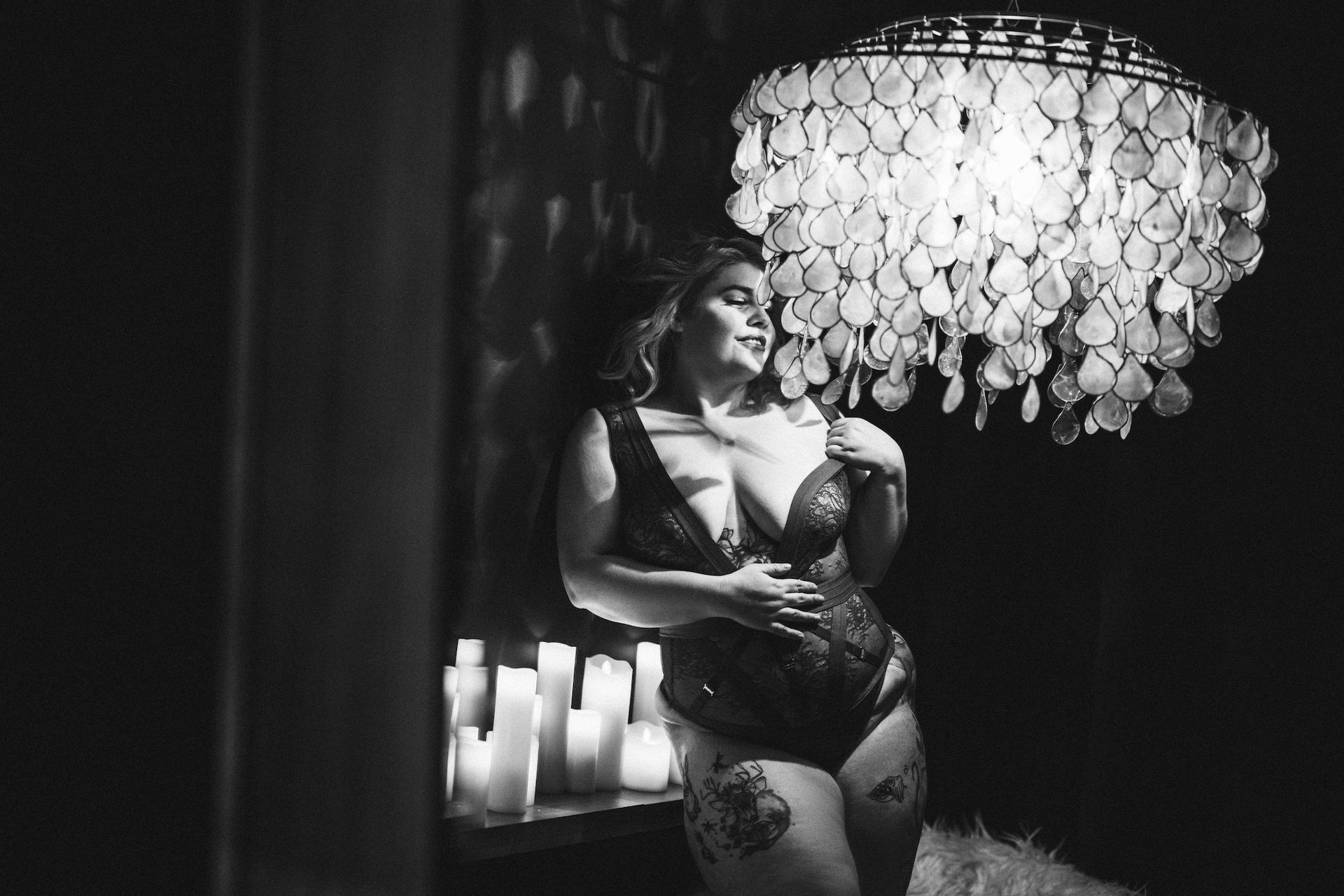 girl wearing lingerie facing to a chandelier