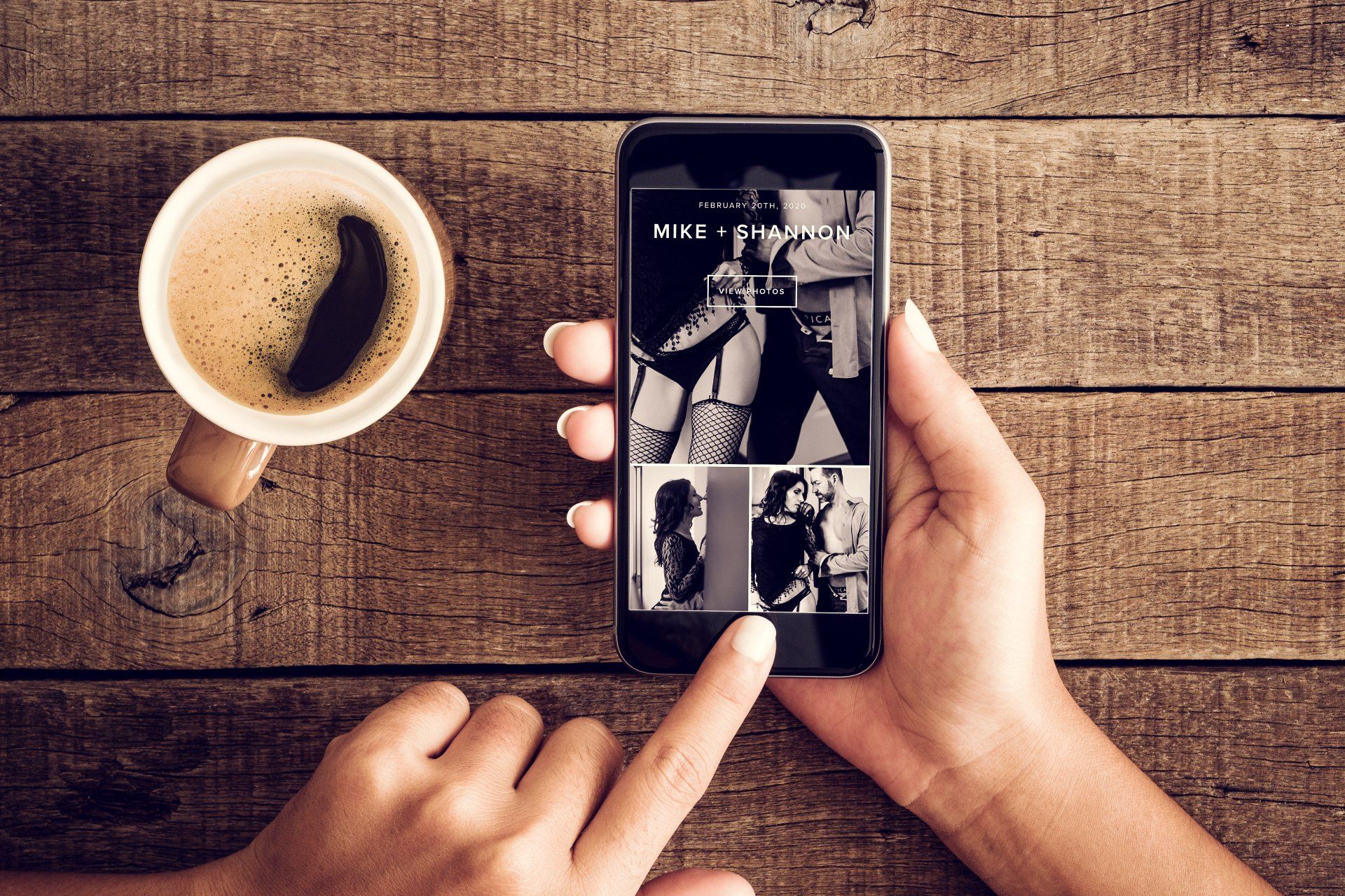 A woman's hand holds a smartphone displaying a photo of another woman. The image includes a coffee.
