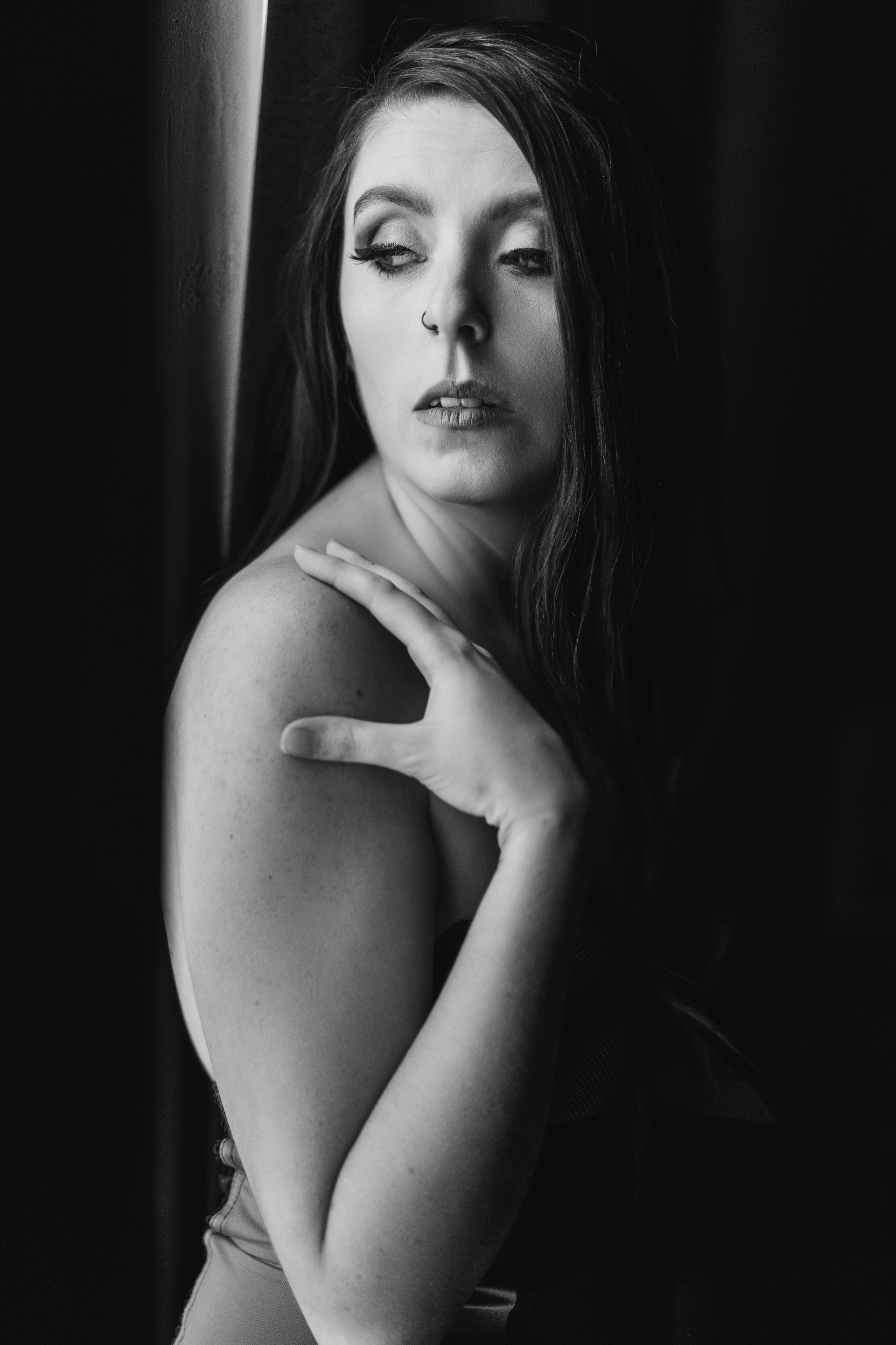 boudoir image of woman looking out window