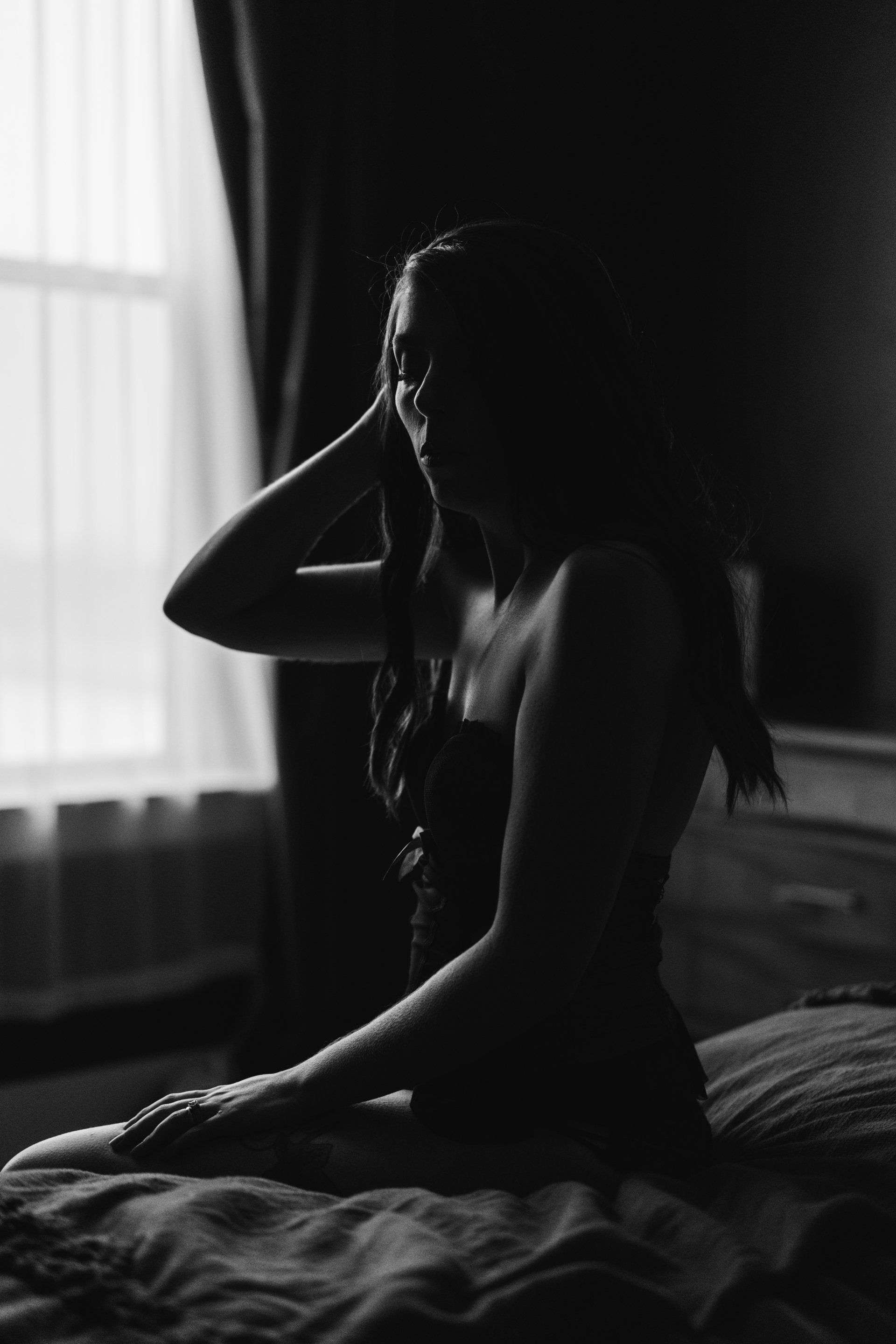 moody boudoir image of woman on bed