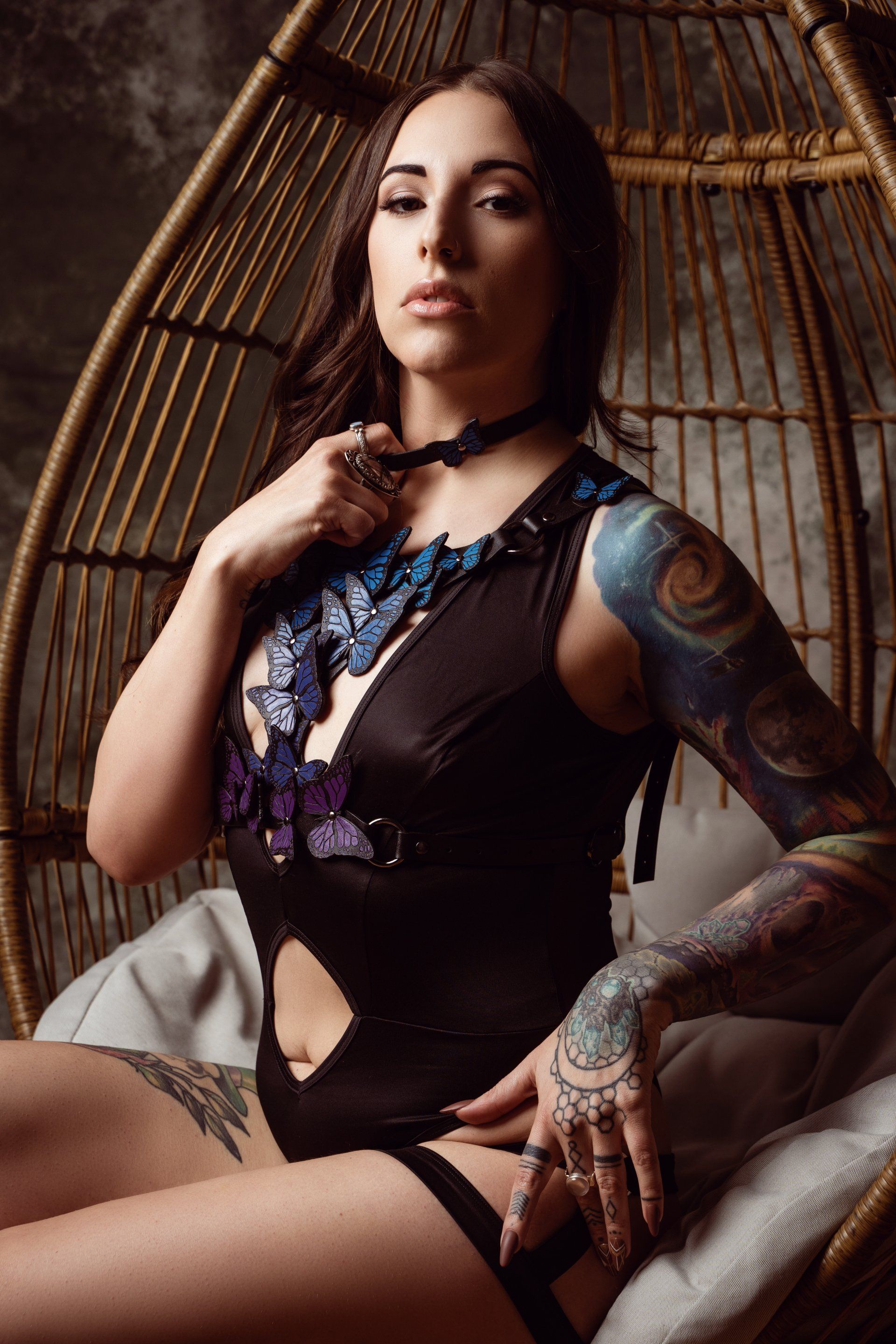 woman sitting in teardrop chair wearing butterfly harness