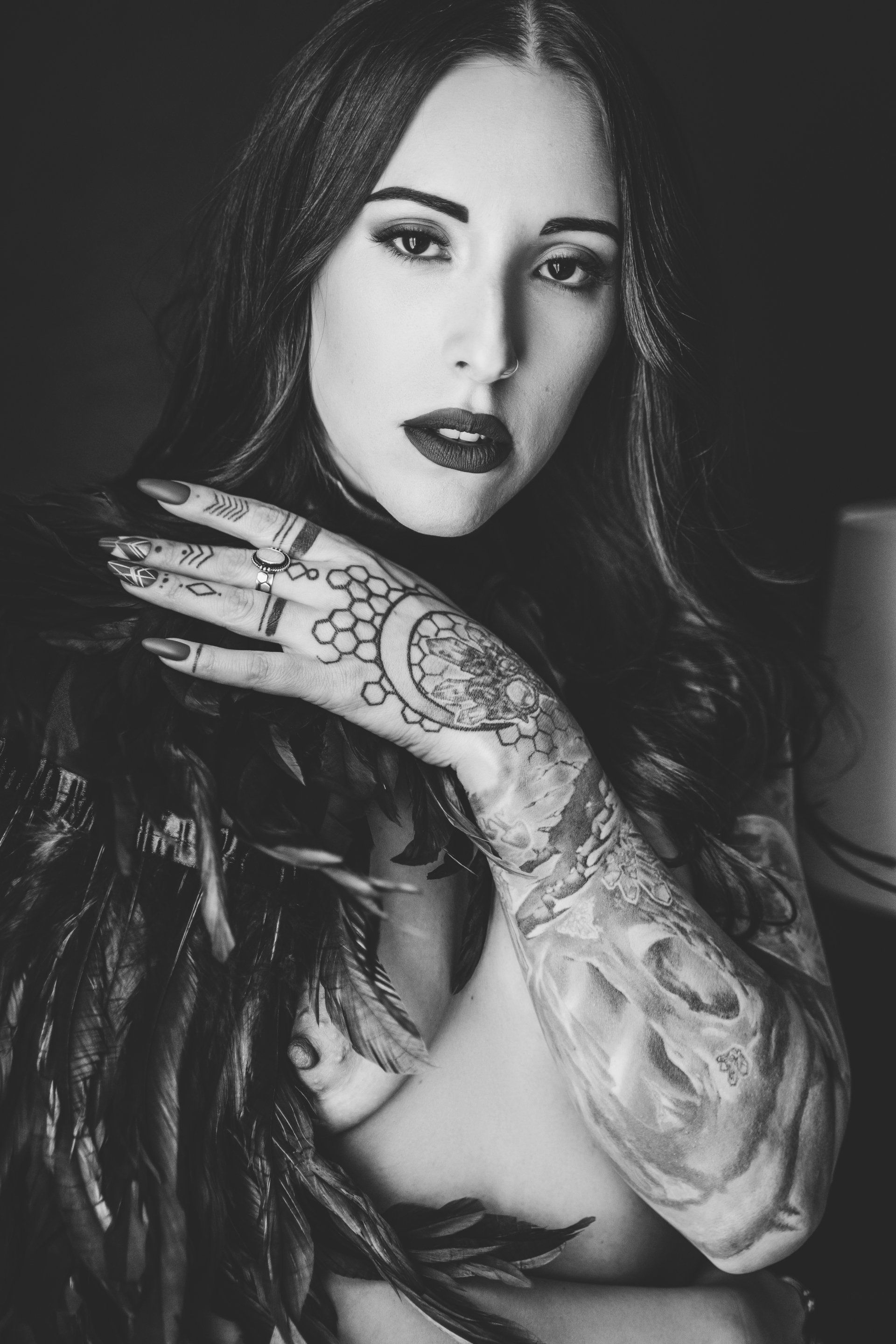 witchy boudoir black and white image of woman wearing feathers