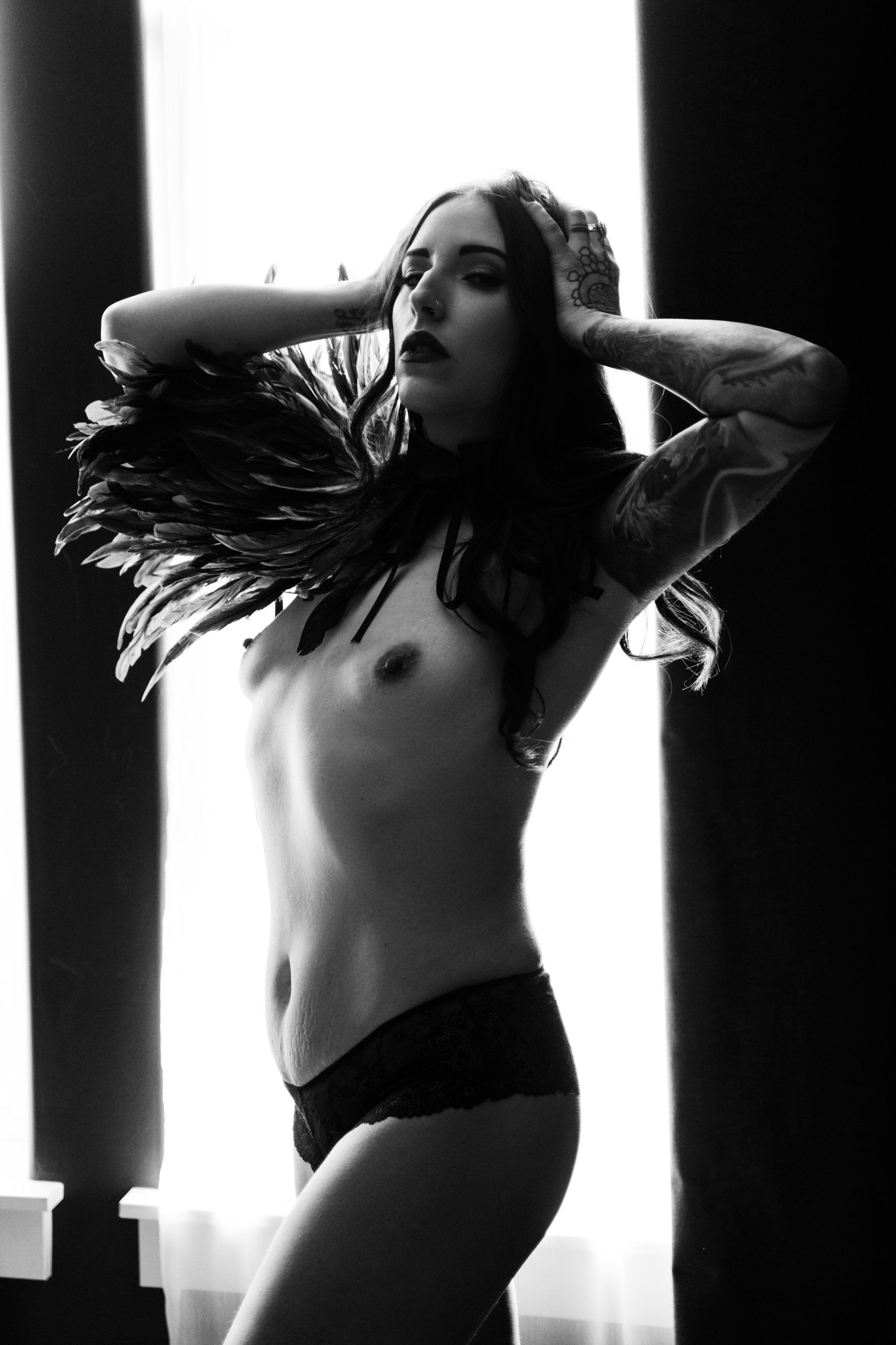 witchy boudoir image of woman wearing feathers