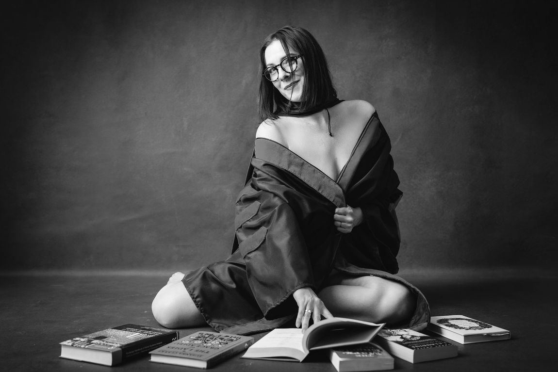 A woman is sitting on the floor with a book.