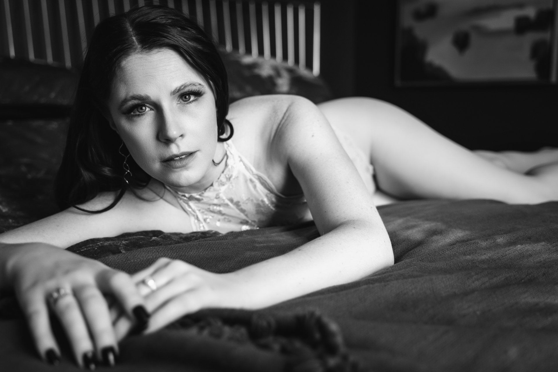 bridal boudoir woman lying on bed looking into camera