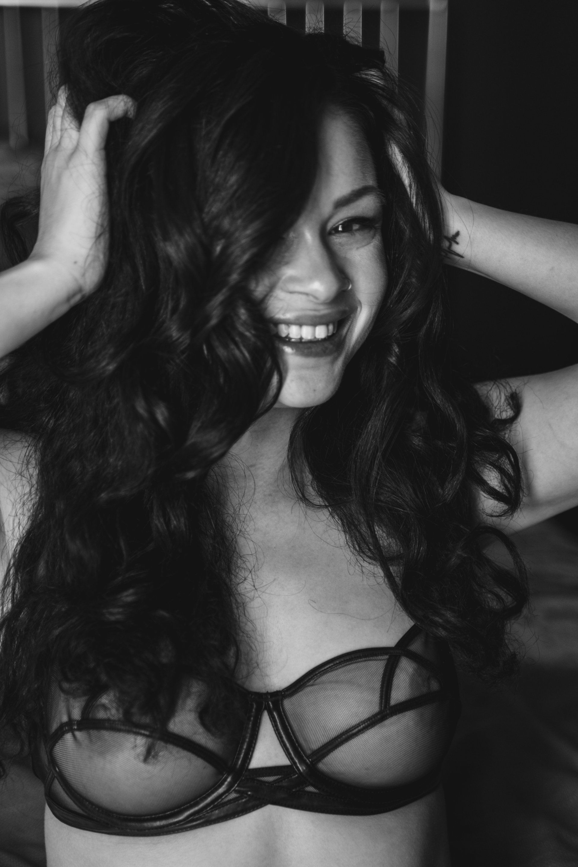 portrait of a woman smiling with hands in hair