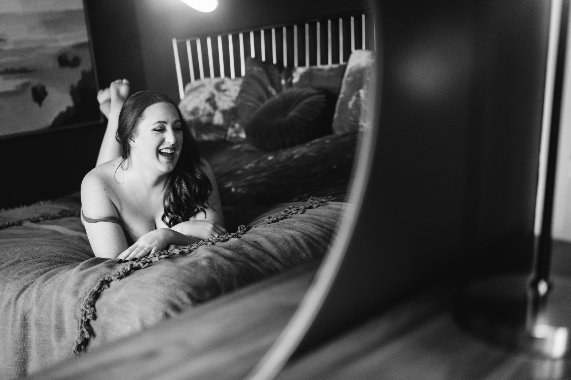 best utah portrait studio woman laying on bed and laughing