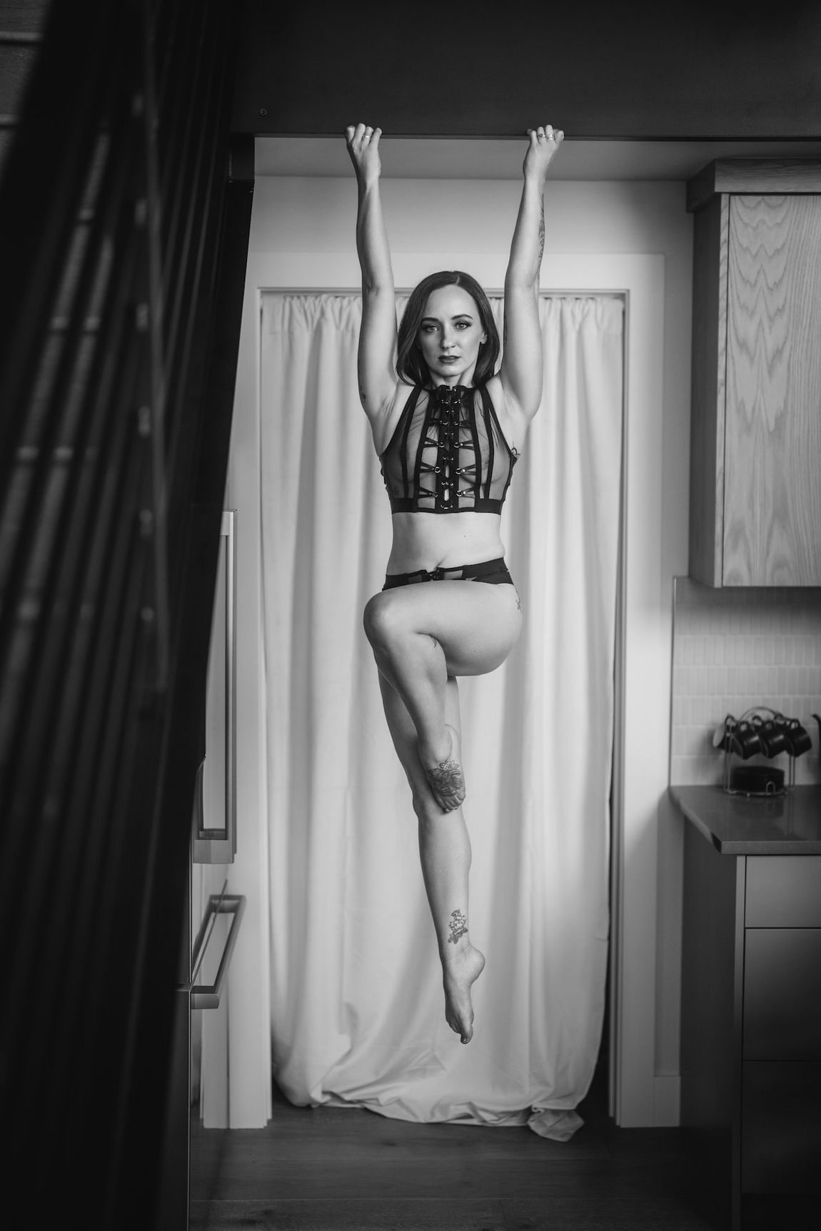 A woman is depicted hanging from the ceiling, evoking a sense of intrigue and artistic expression.