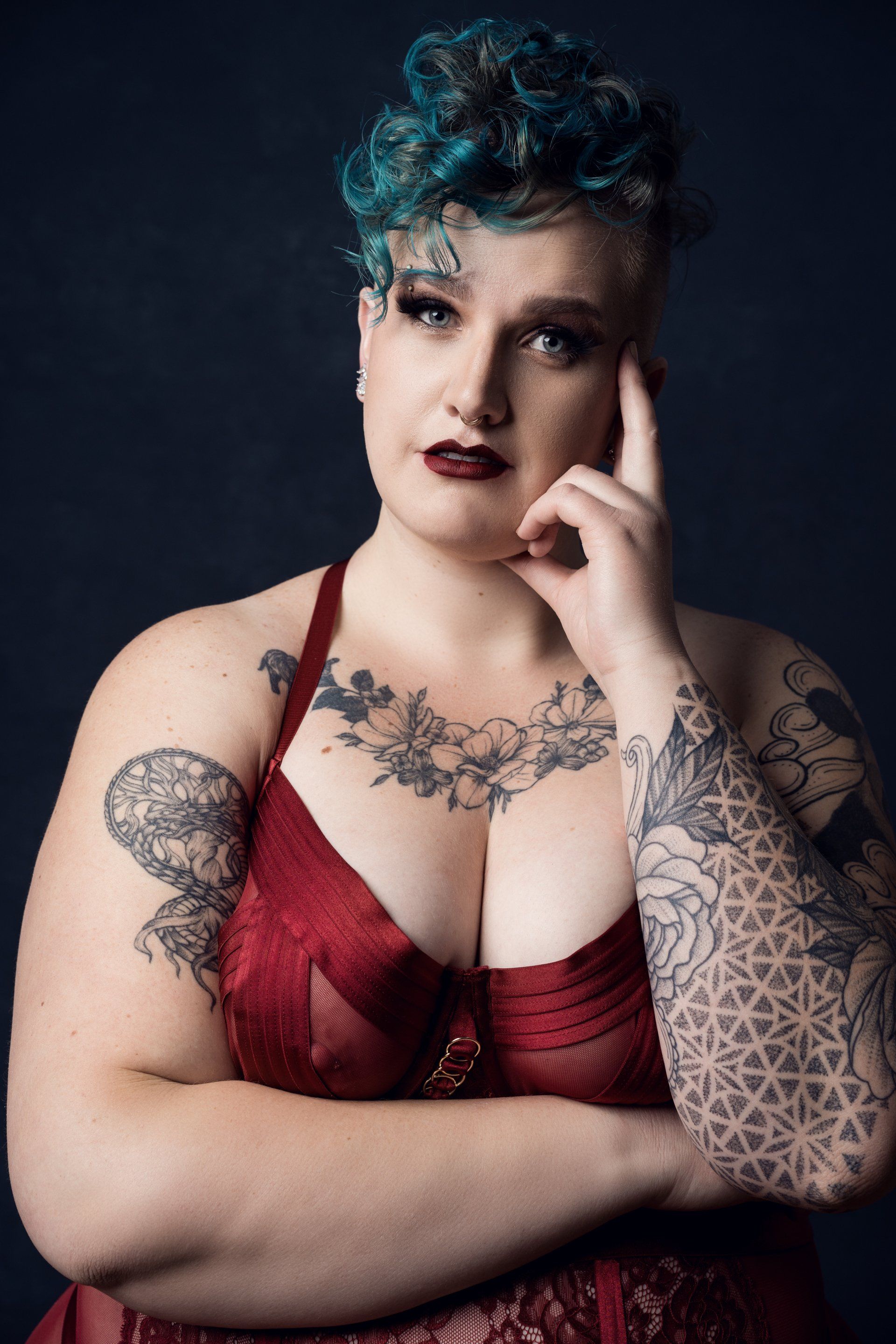 boudoir photoshoot in color, woman with blue hair in red lingerie