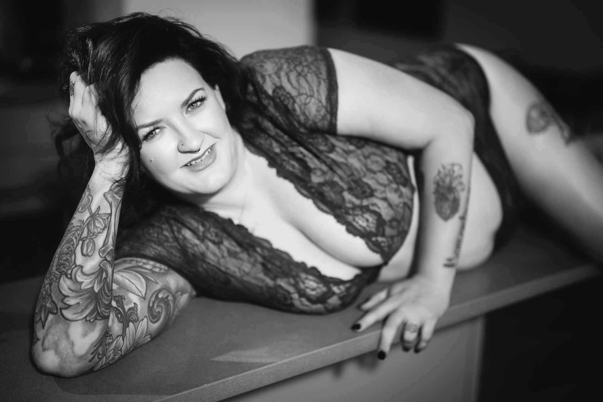 Black and White Boudoir photo of a woman reclined on the kitchen counter
