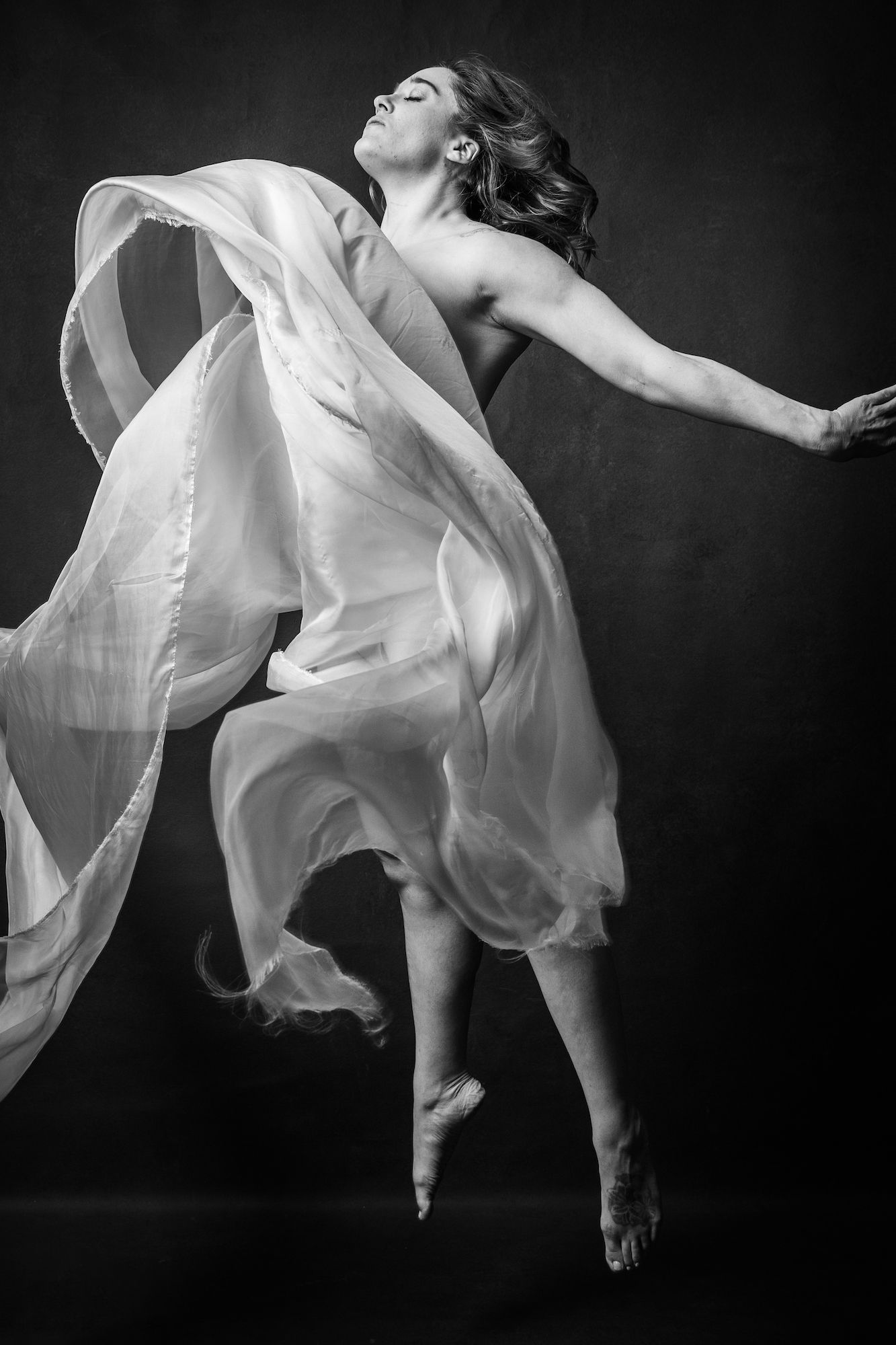 Woman in white dress jumping joyfully.