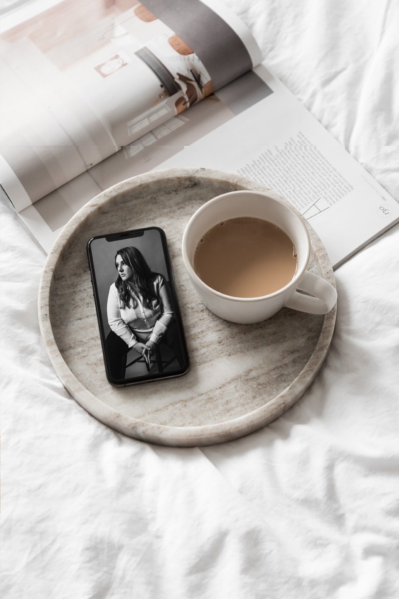 Coffee cup and magazine on bed