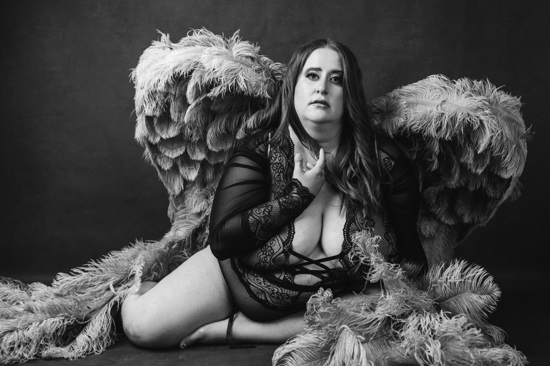 photograph of a curvy woman wearing large wings during her boudoir session in Utah