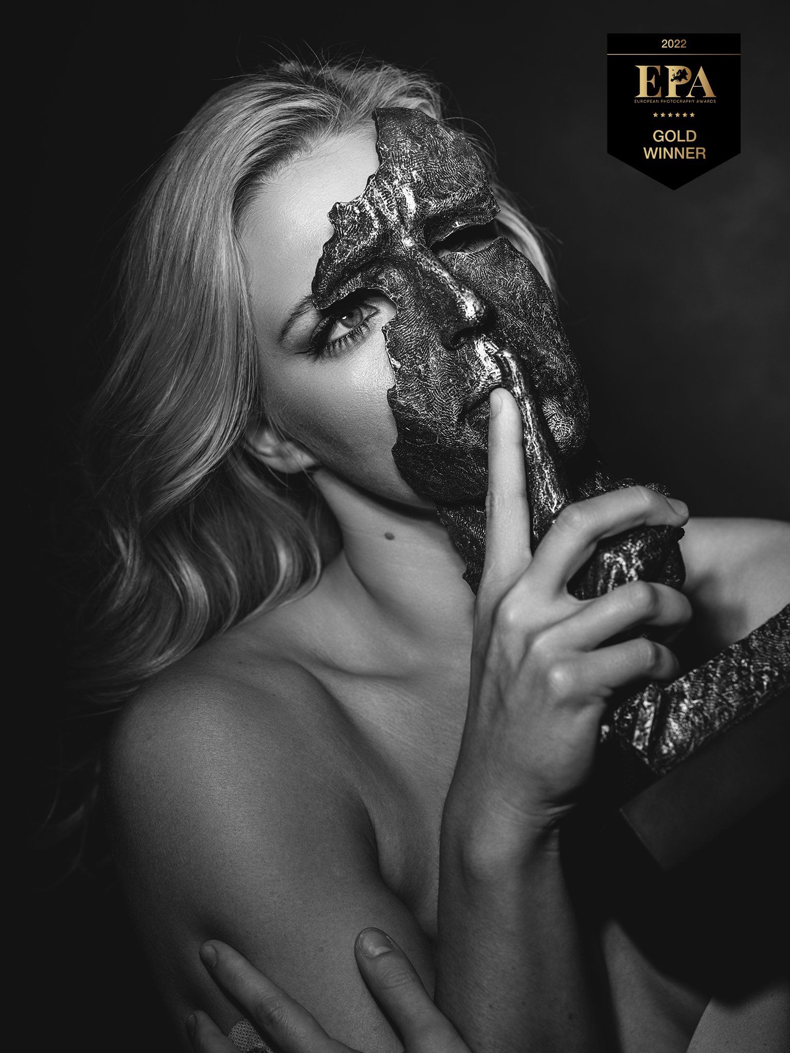 woman holding a mask in front of her face