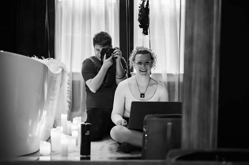 A couple enjoying a relaxing moment in a bathtub filled with water, surrounded by flickering candles.