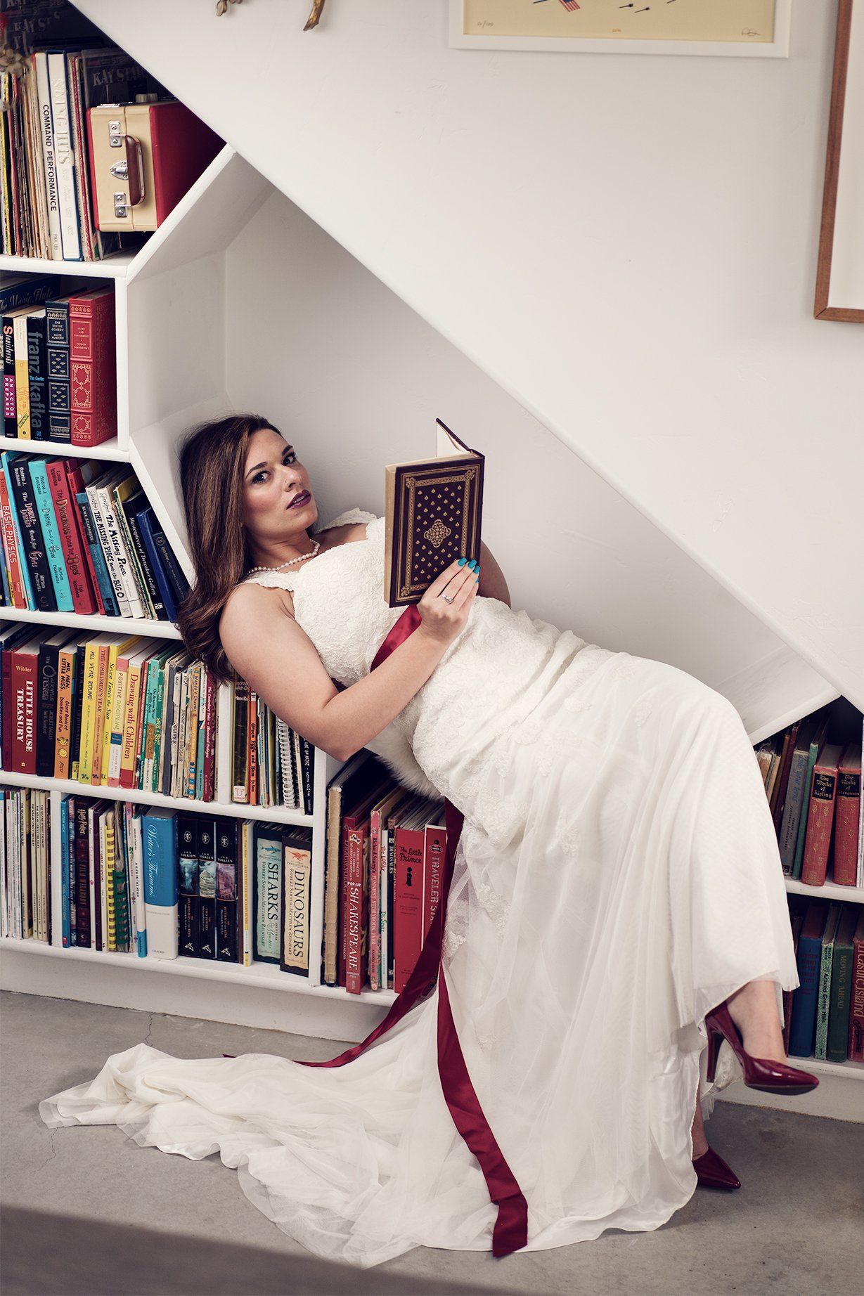 A woman with gown posing with a book for a Bridal Boudoir
