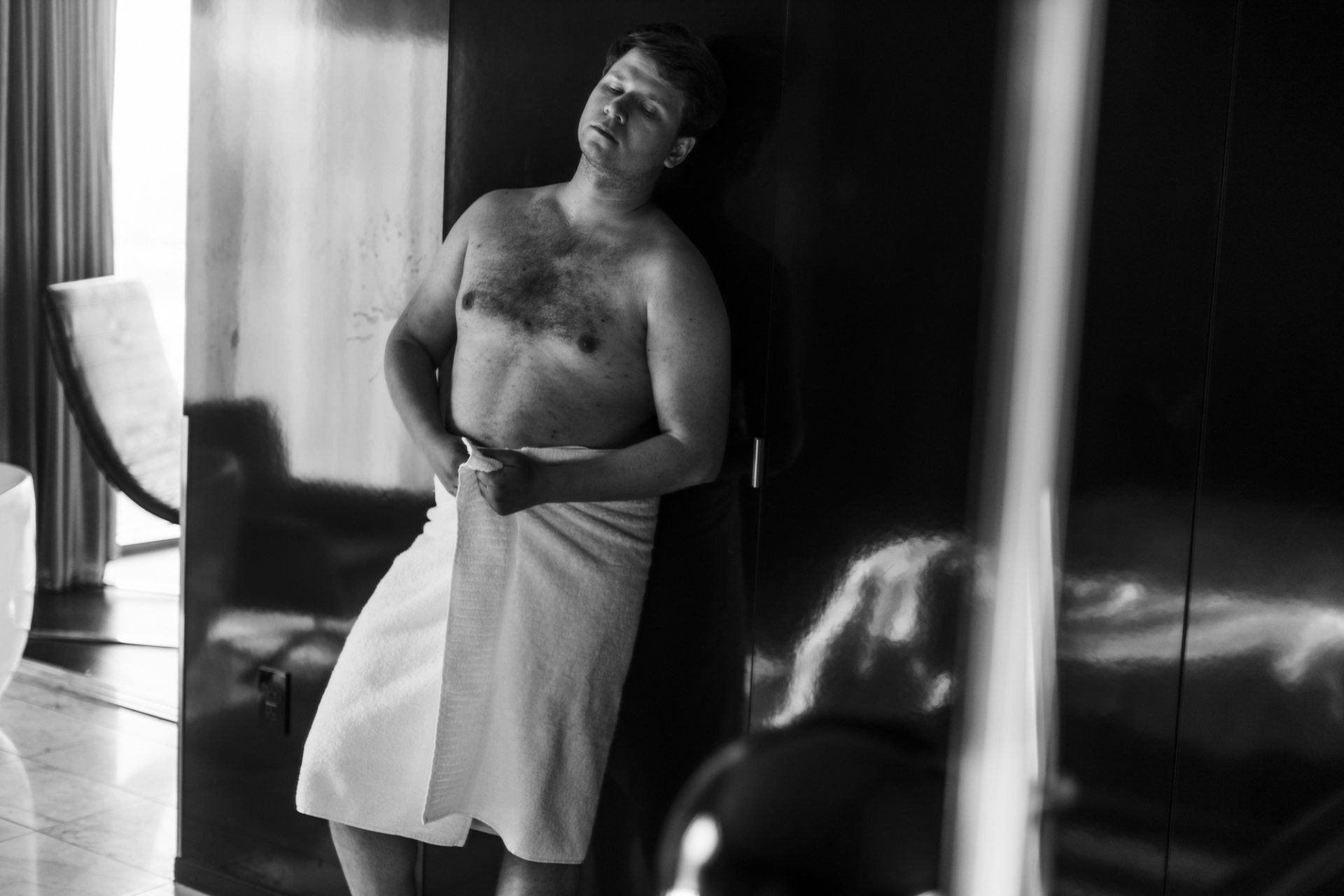 man standing wrapped only in a towel at the boudoir experience