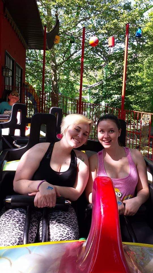 Two women enjoying a thrilling roller coaster ride together.