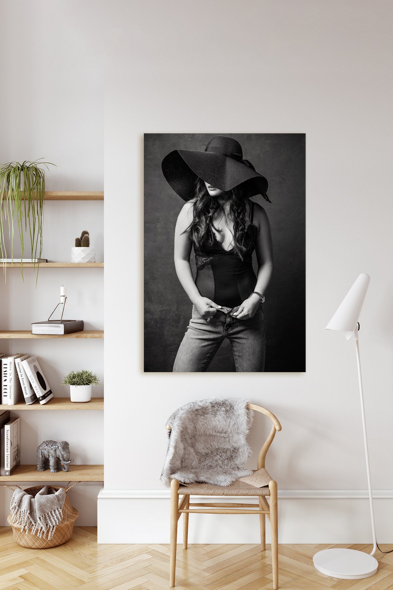 In a living room, a photo frame of a woman wearing a hat is hanging on the wall.