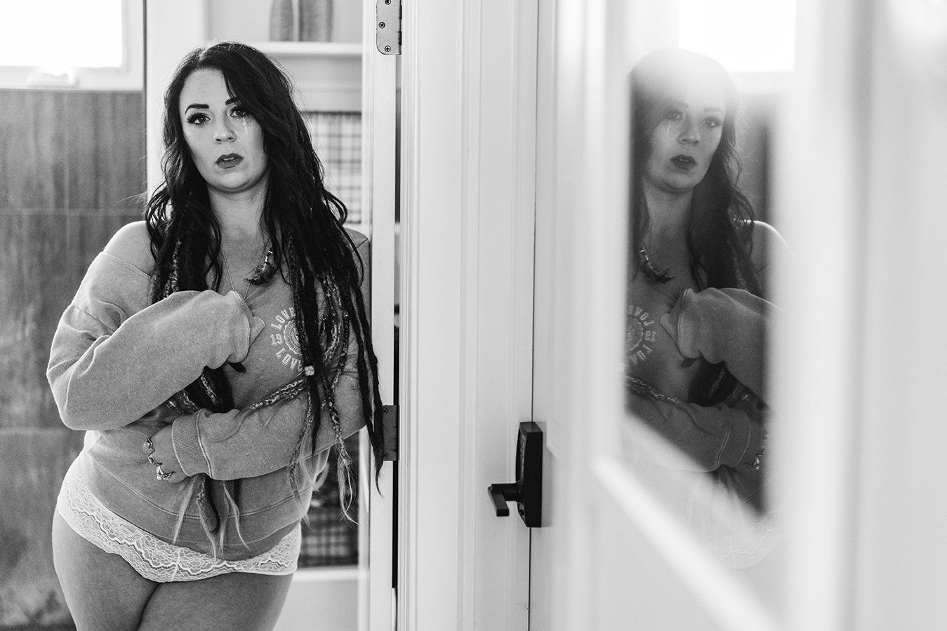 Utah boudoir photography woman standing next to a mirror and posing during her boudoir session in Ogden Utah