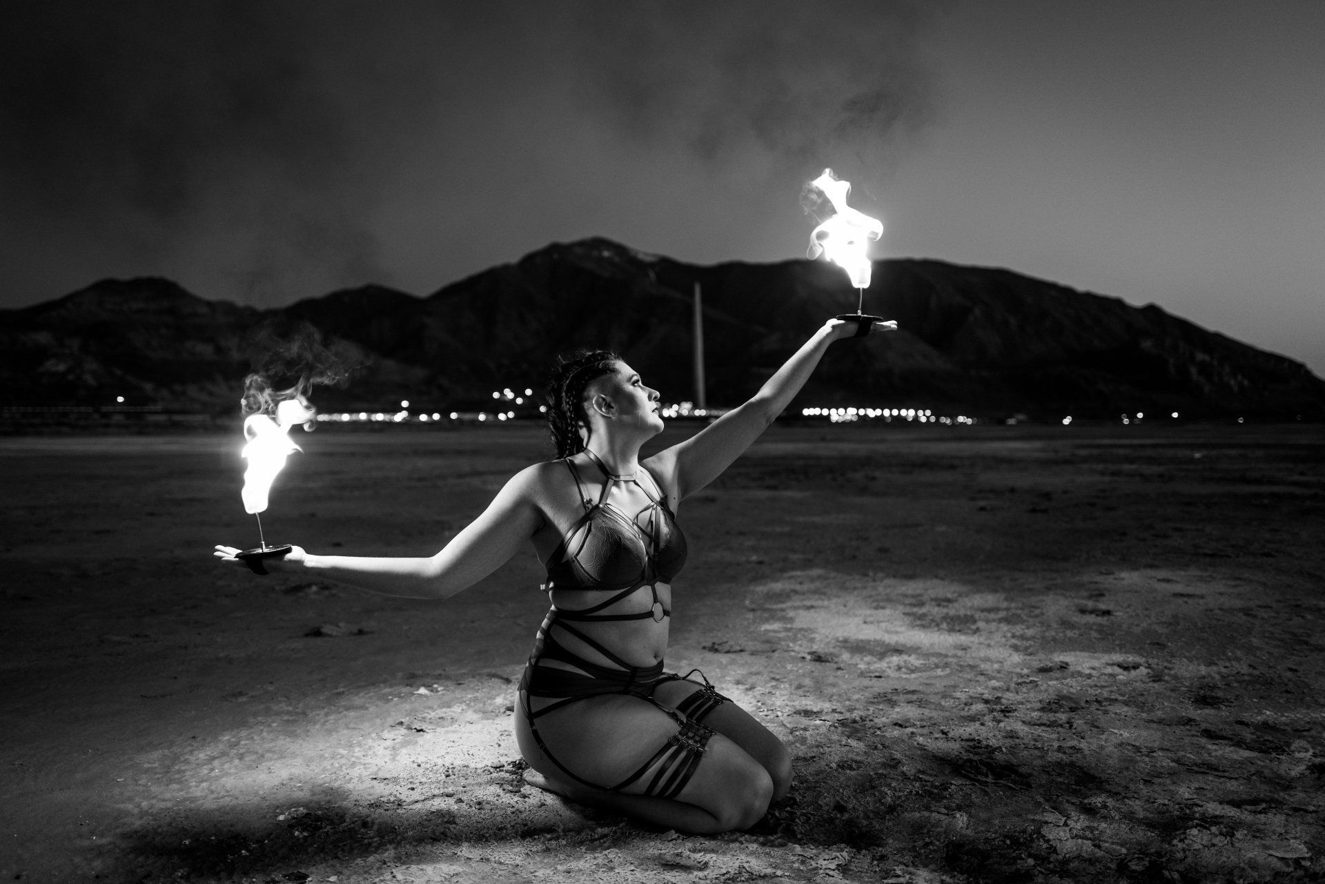 A woman in a bikini holding two torches, radiating strength and confidence.