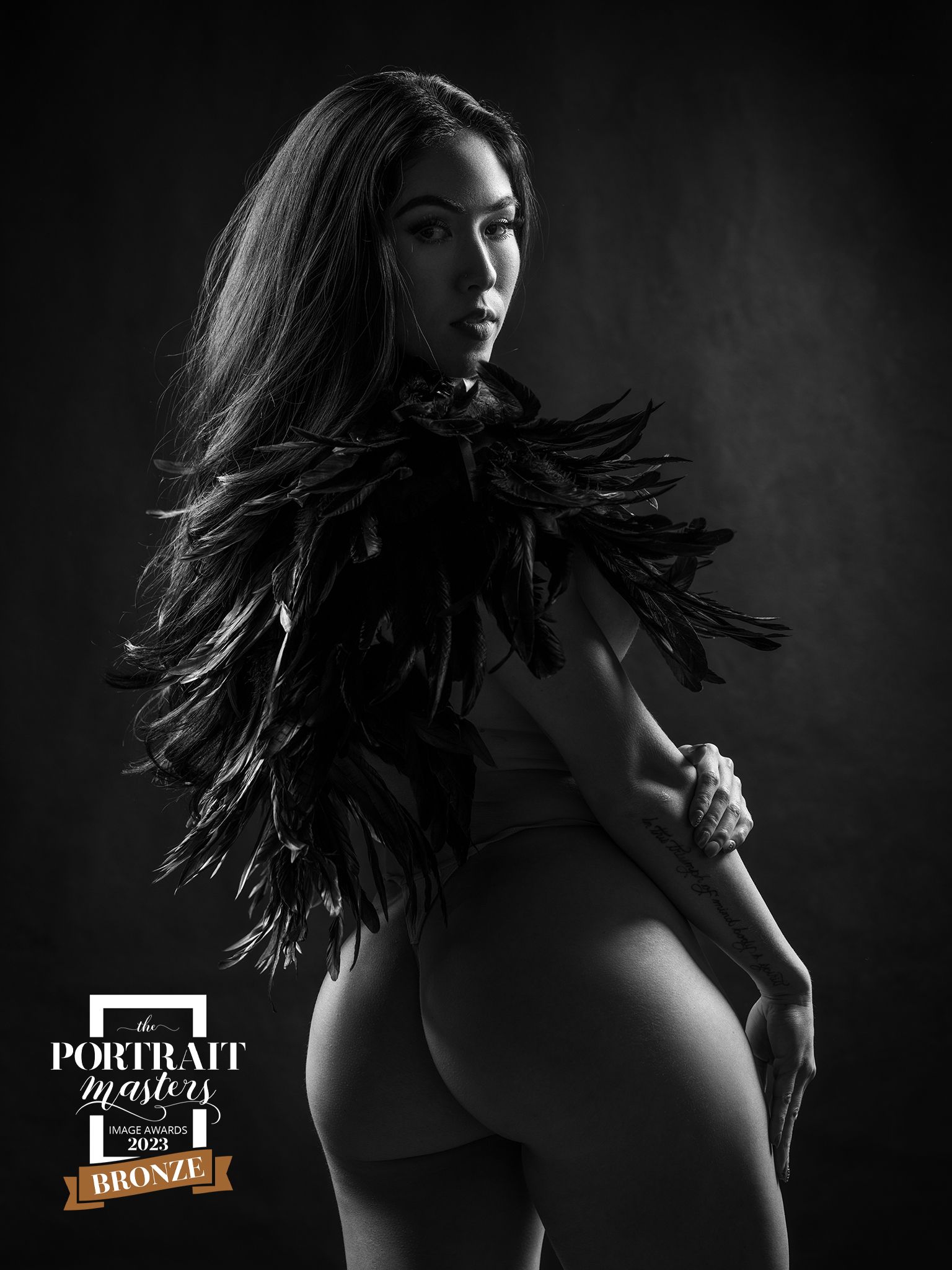 woman wearing black feathers looking over her shoulder