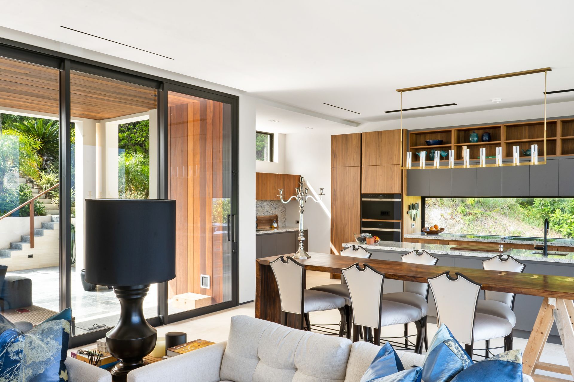 A living room with a couch , table , chairs and a lamp.
