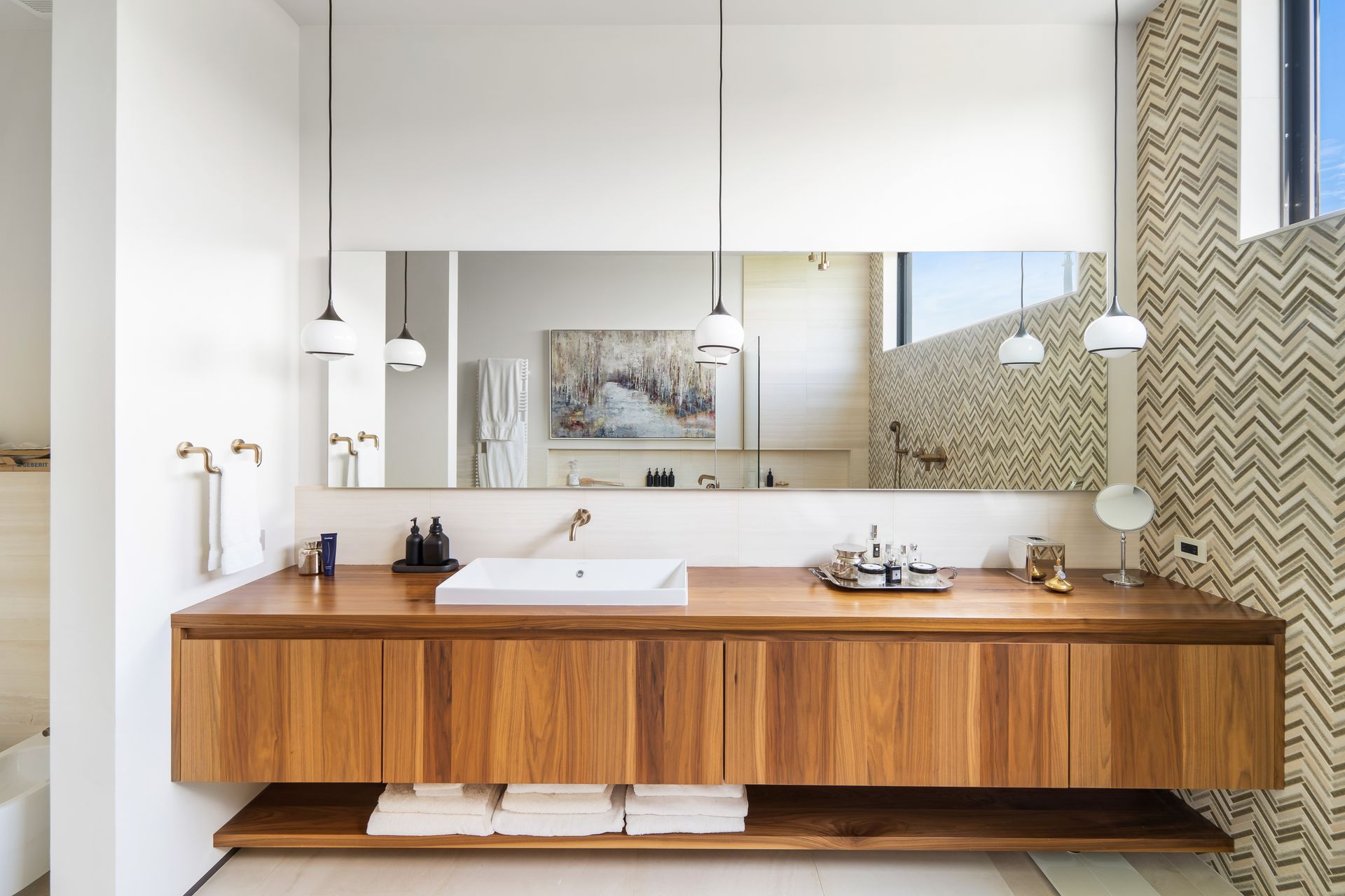 A bathroom with a sink , mirror and wooden cabinets