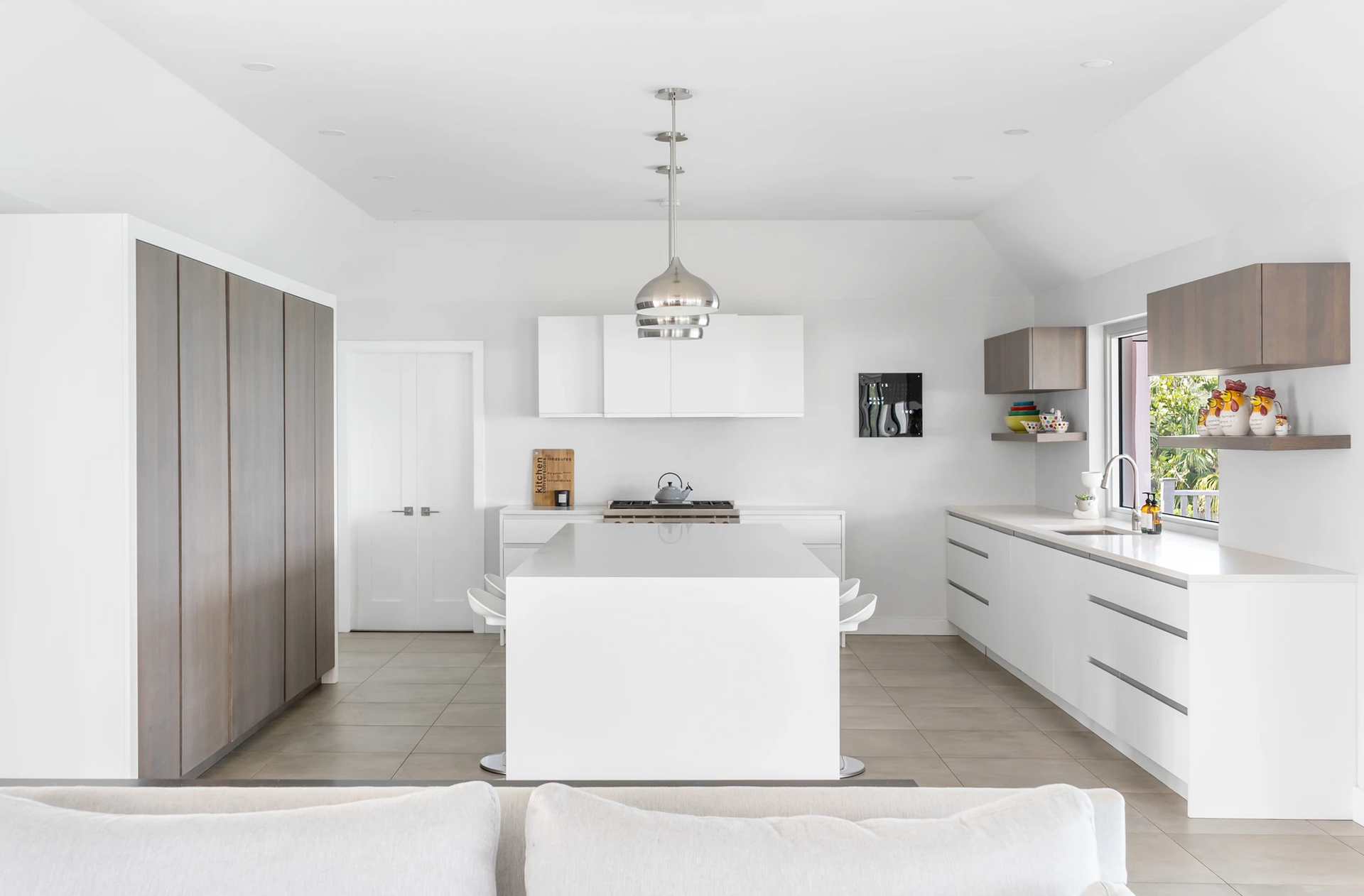 A kitchen with white cabinets and a large island in the middle.