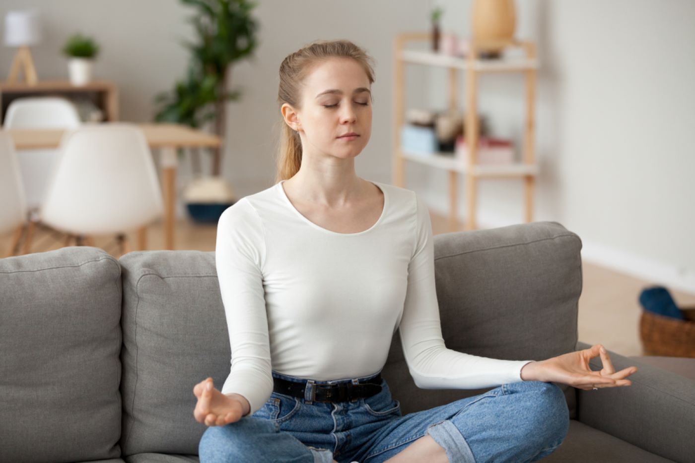 A Woman Is Sitting on A Couch in A Lotus Position — Moving Beyond OK In Cornubia, QLD