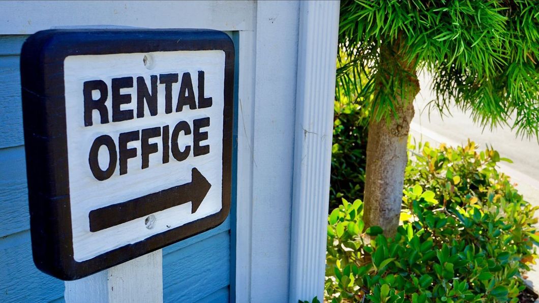 A rental office sign with an arrow pointing to the right