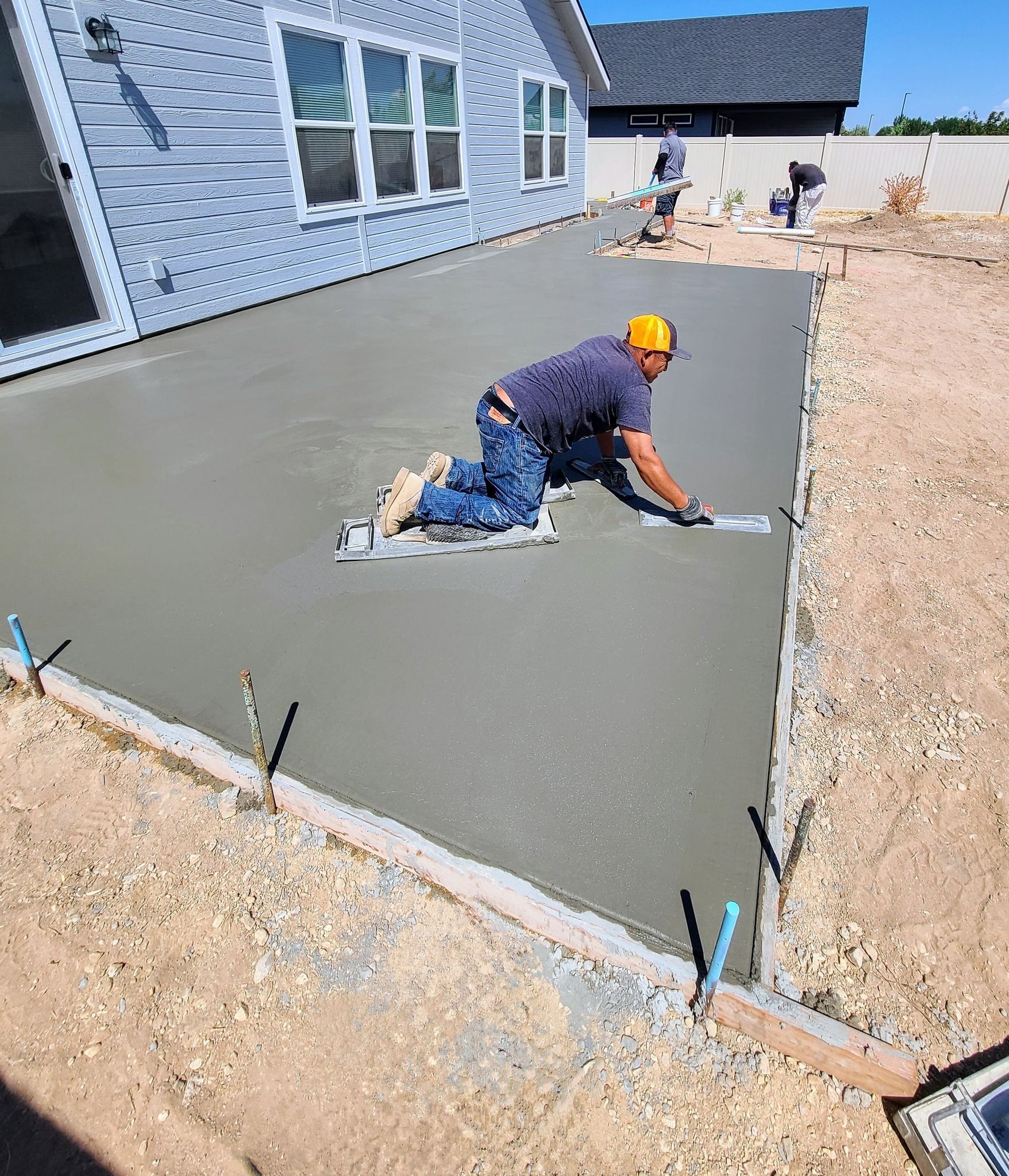 Worker troweling smooth wet concrete paving section, worked on by Elite Form Concrete in Eagle Mountain, UT.