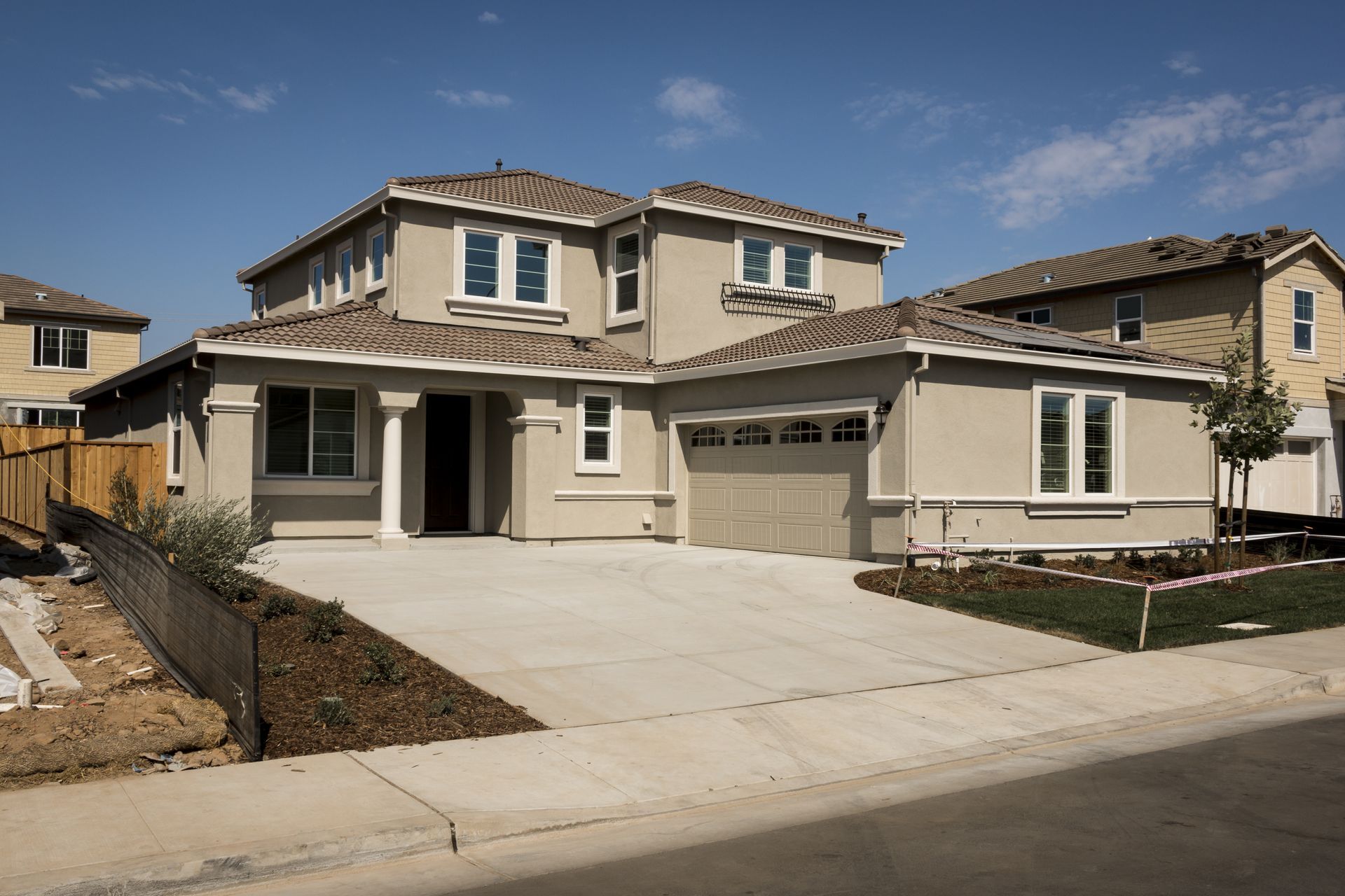 Wide concrete driveway with dual garages in modern home installed by Elite Form Concrete in Los Ranchos, NM.