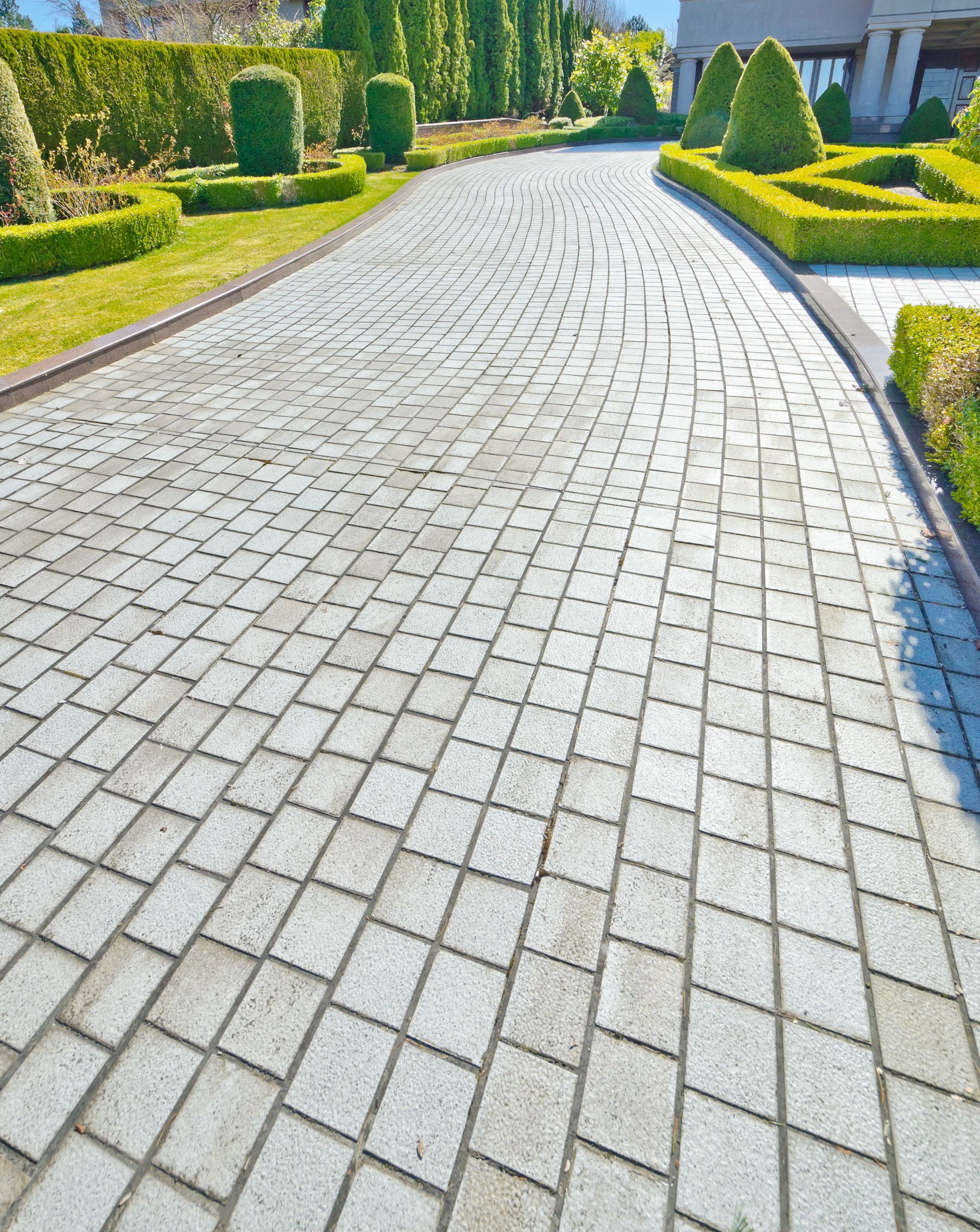 Gray paver walkway with clean border edges and curve, worked on by Elite Form Concrete in Rio Rancho, NM.