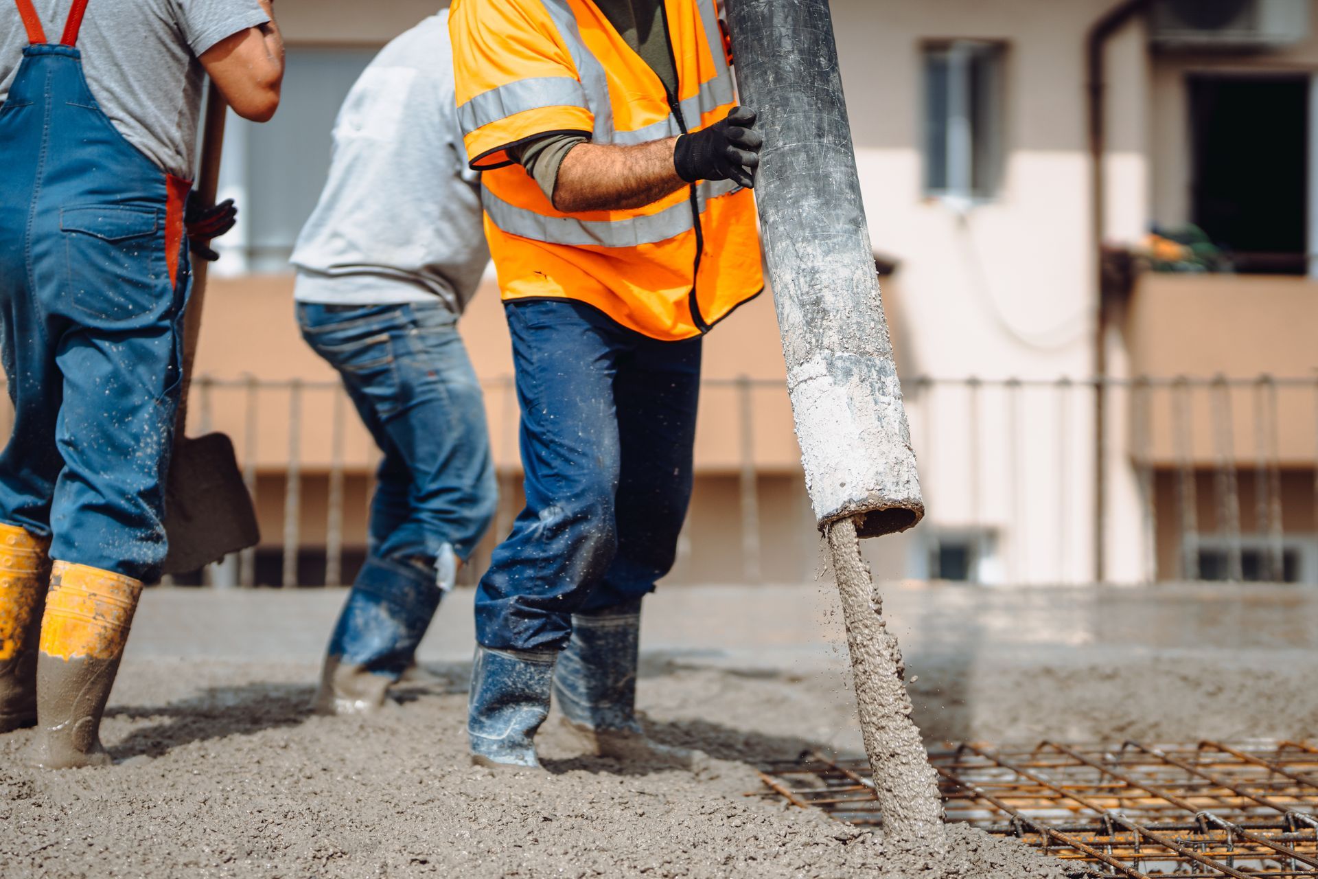 Workers guiding concrete pour into slab foundation forms, worked on by Elite Form Concrete in Rio Rancho, NM.