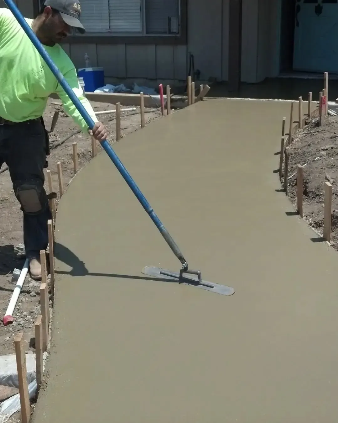Crew finishing decorative concrete paving with blue float, worked on by Elite Form Concrete in Eagle Mountain, UT.