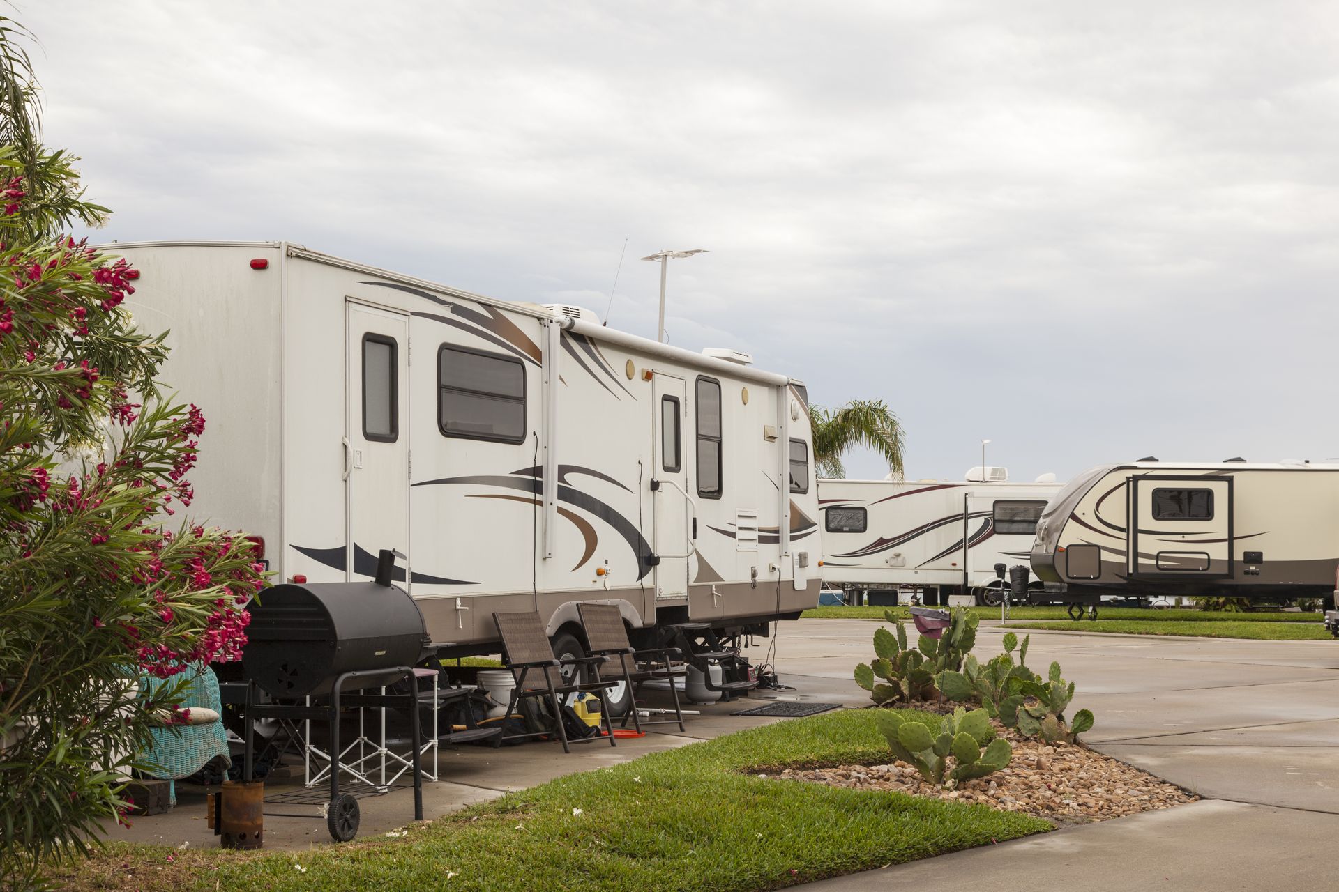 Concrete RV pads beside large white RVs in campground, worked on by Elite Form Concrete in Rio Rancho, NM.