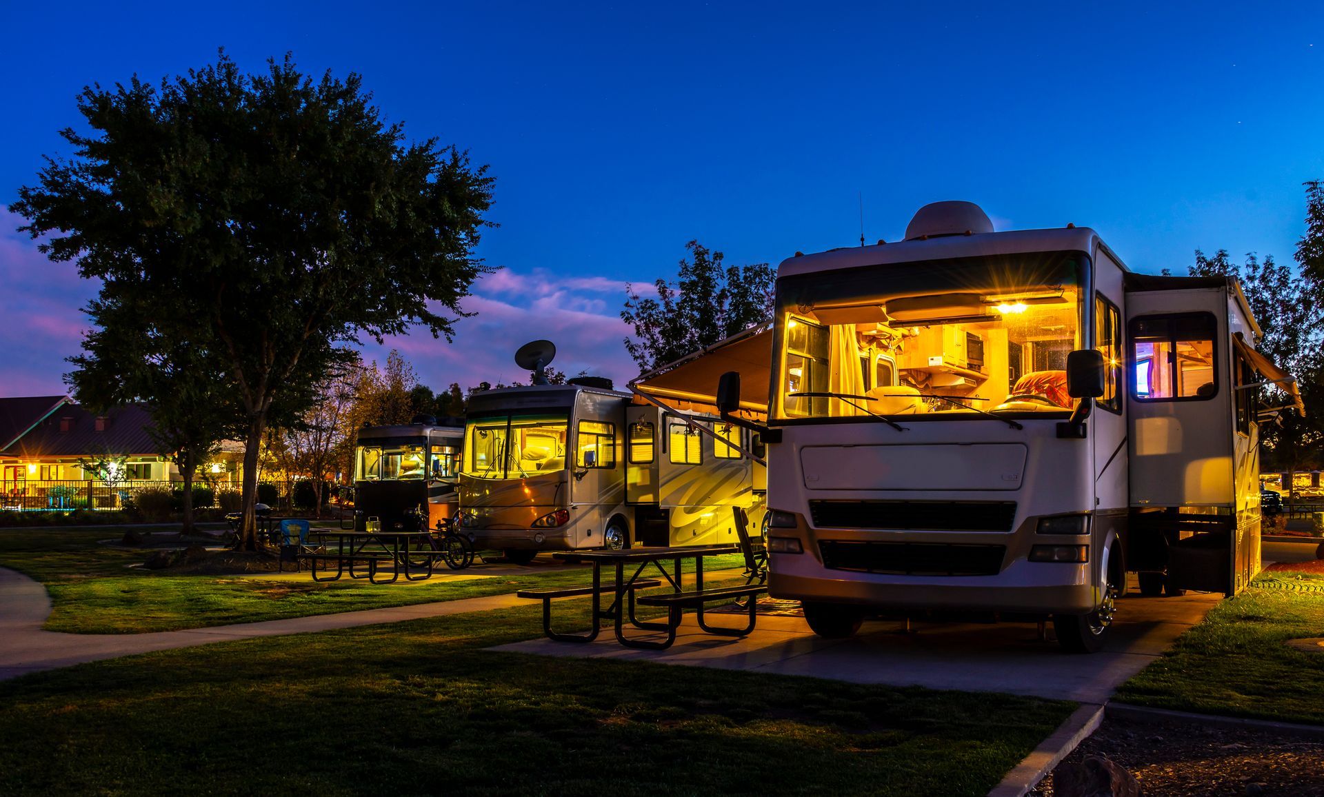 Evening shot of RV parked beside concrete pad with lights, worked on by Elite Form Concrete in Eagle Mountain, UT.