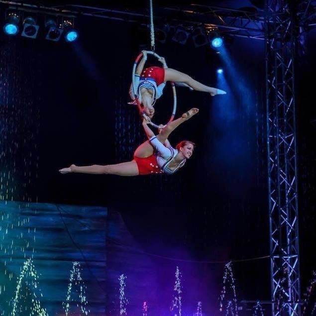 Two women are performing aerial acrobatics on a stage