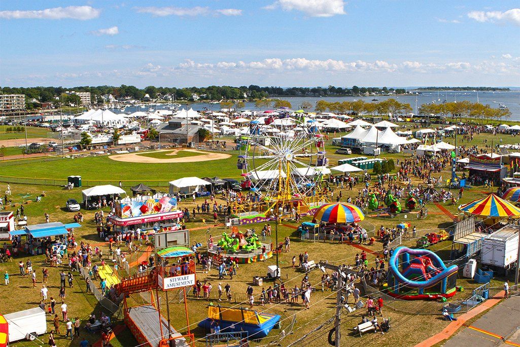 An aerial view of a carnival with a lot of people and rides.