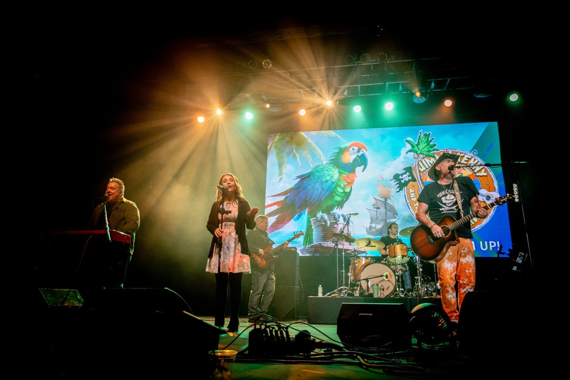 A group of people are playing instruments on a stage in front of a crowd.