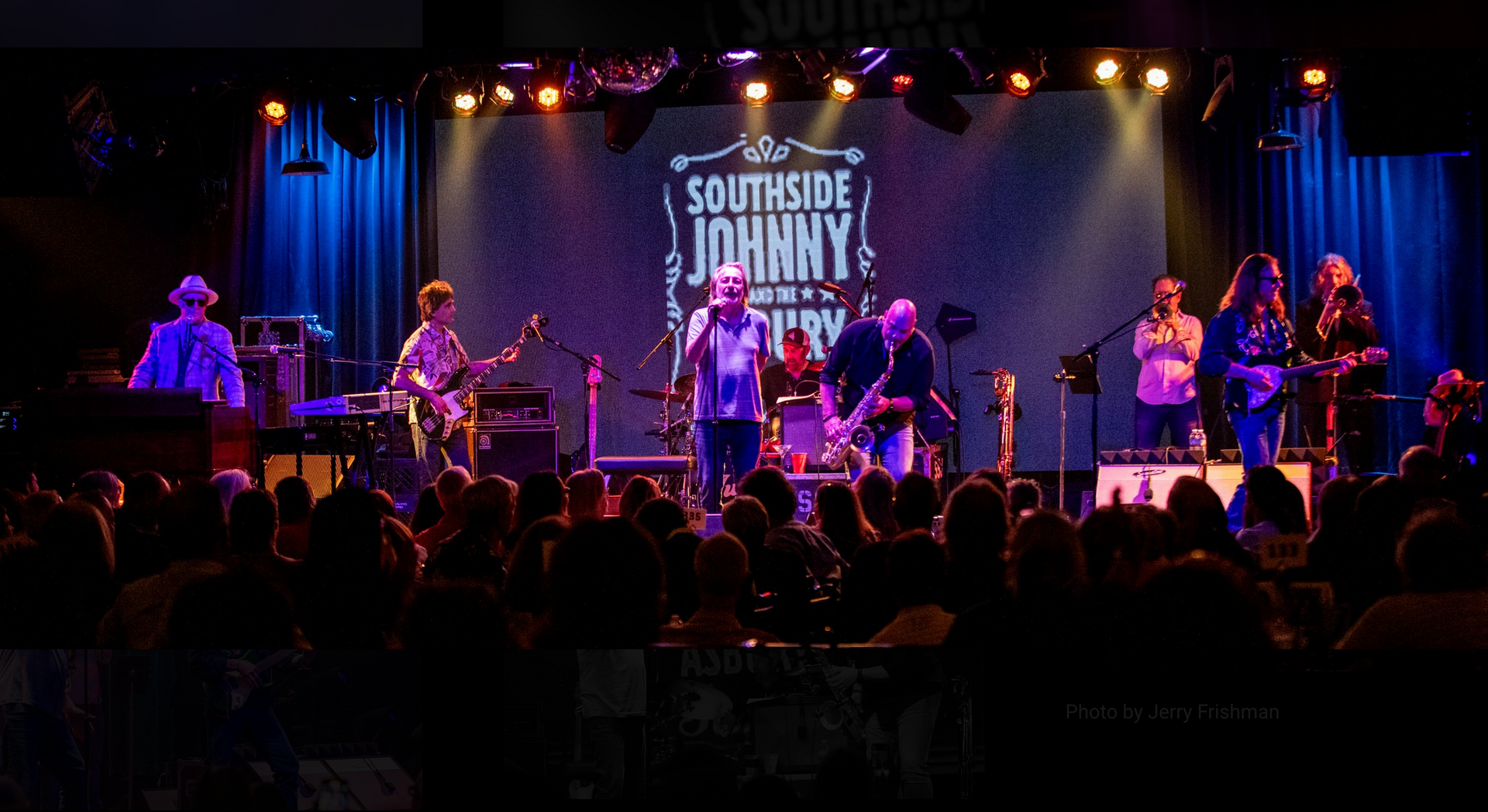 A group of people are playing instruments on a stage in front of a crowd.