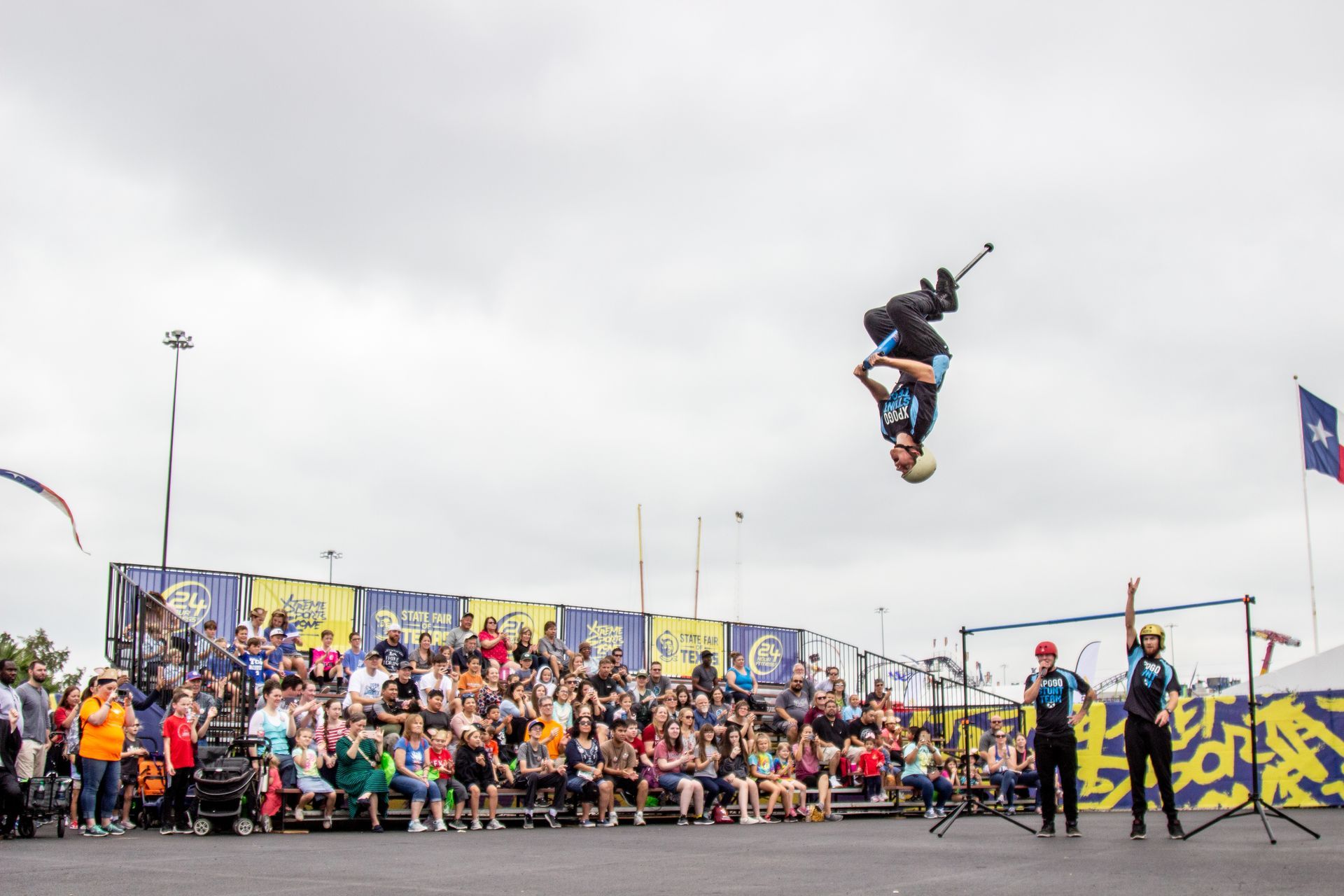 A person is doing a trick in the air while a crowd watches.