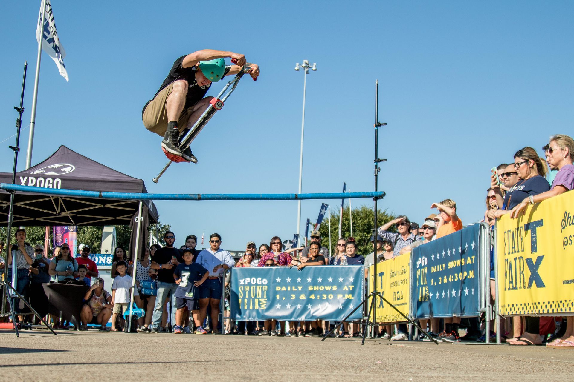 A man is doing a trick on a skateboard while a crowd watches