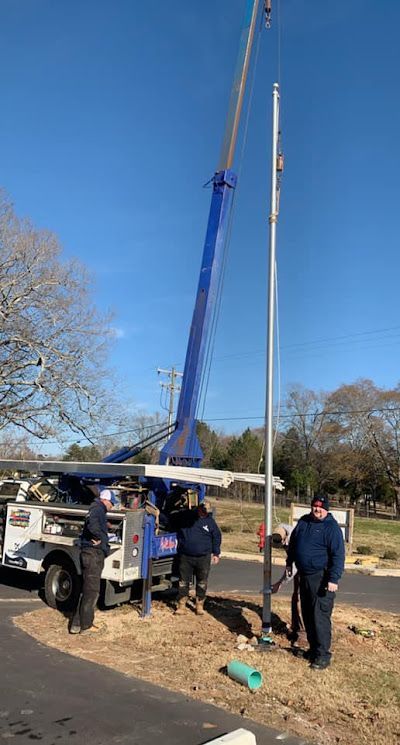 A red truck is parked in a grassy field with trees in the background.