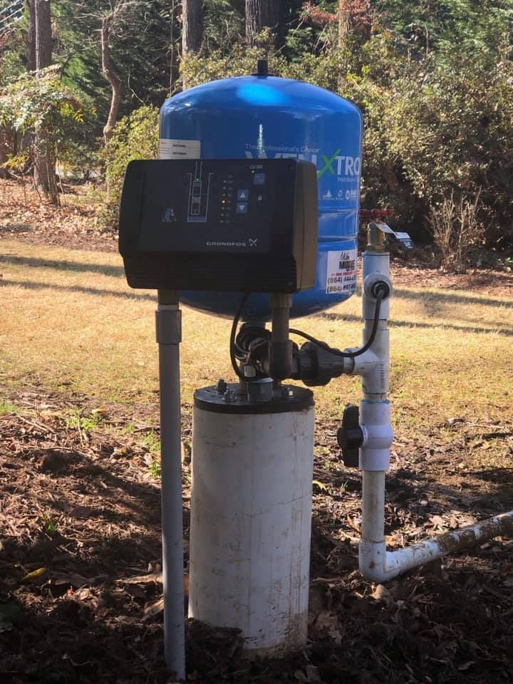A blue water tank is sitting on top of a white cylinder.