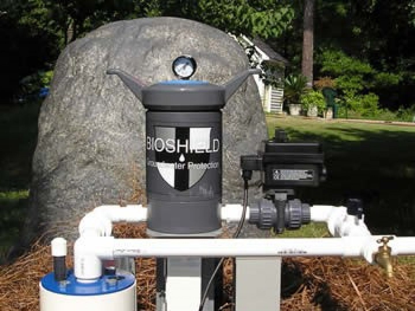 A bioshield device is sitting next to a large rock.