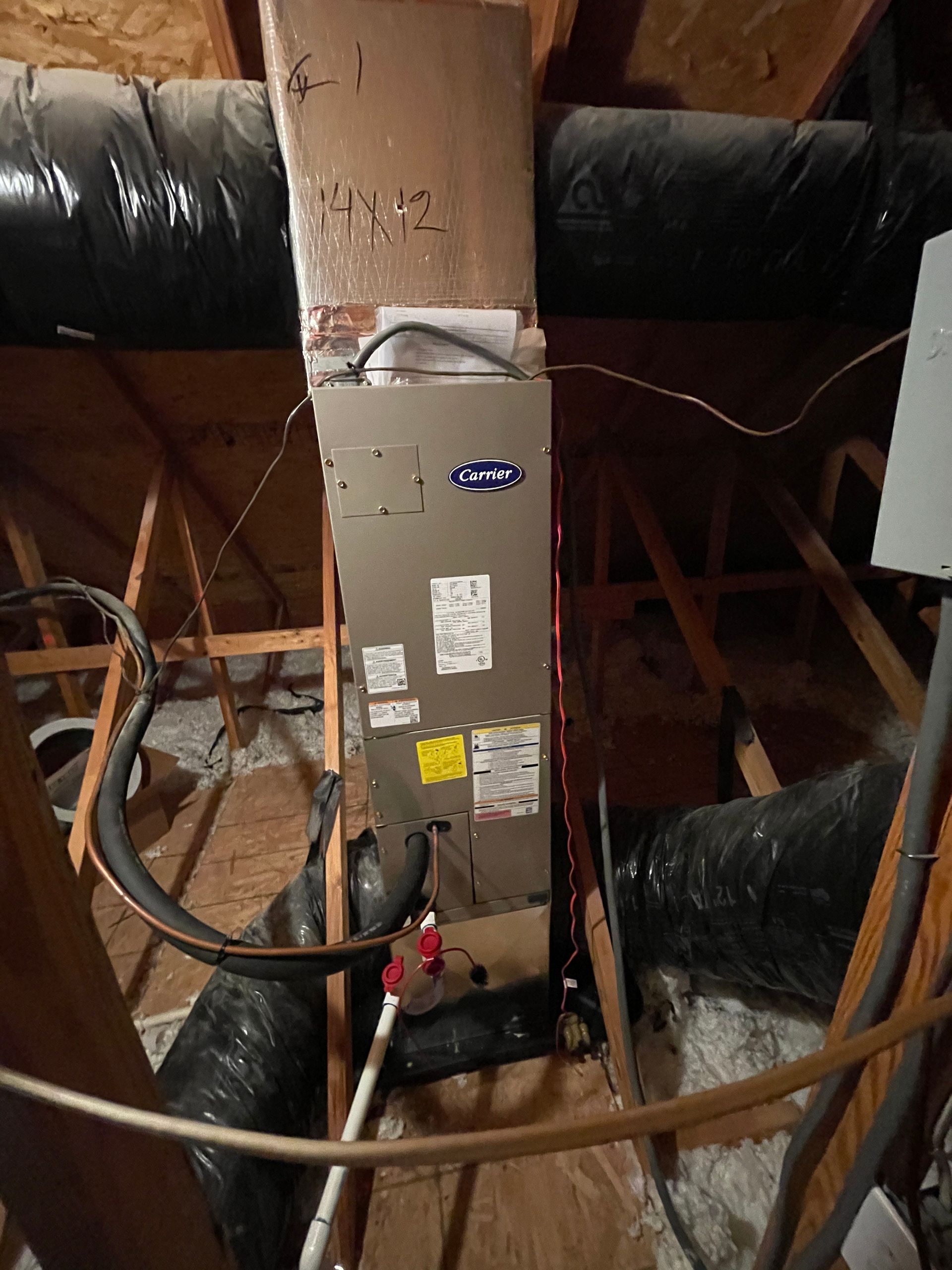 An air conditioner is sitting in the attic of a house.