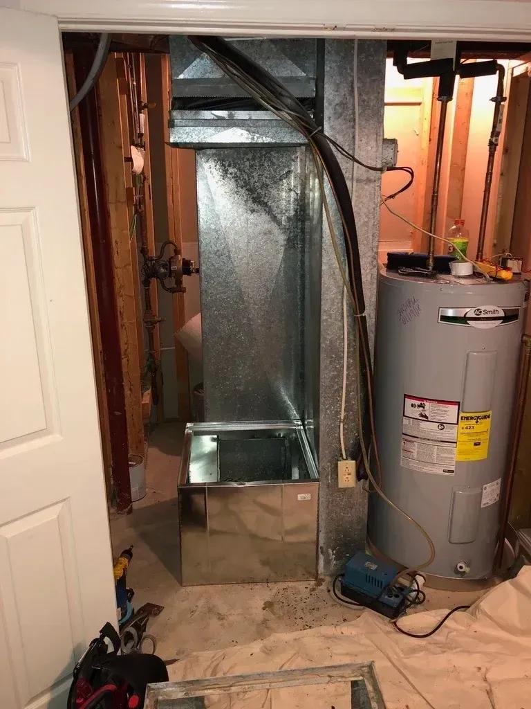 A room with a water heater and an air conditioner in it.