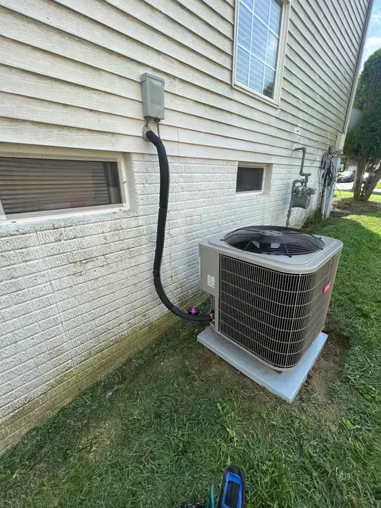 An air conditioner is sitting on the side of a house.